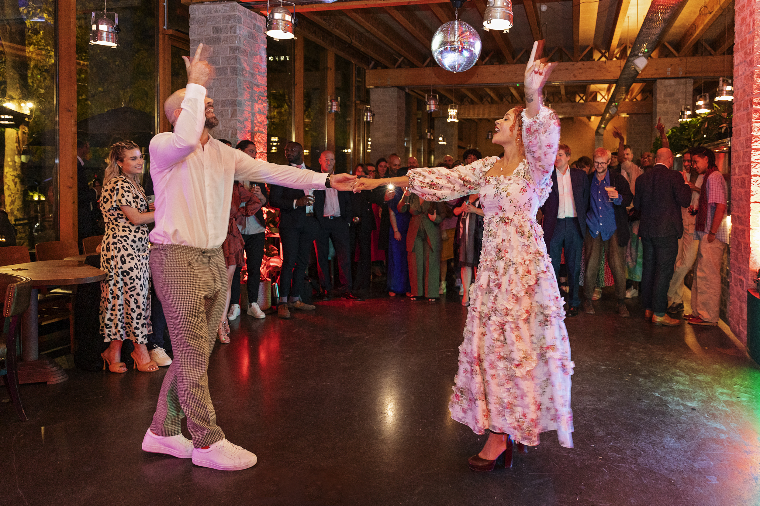 Couple dancing under disco ball at vibrant event in The Greenroom, celebrating connection.