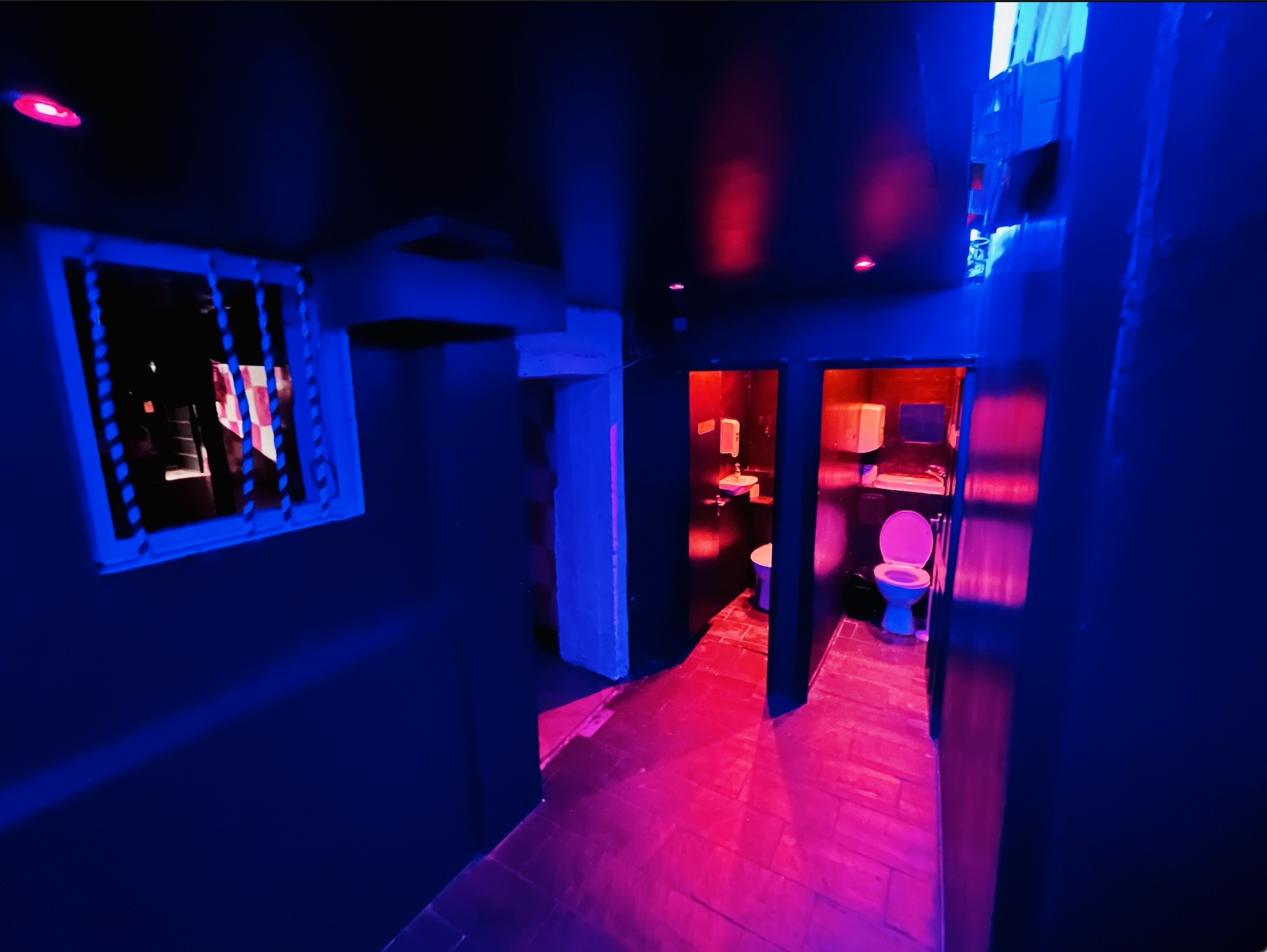 Dimly lit corridor with blue and purple lighting at Bonkers Bar for events.