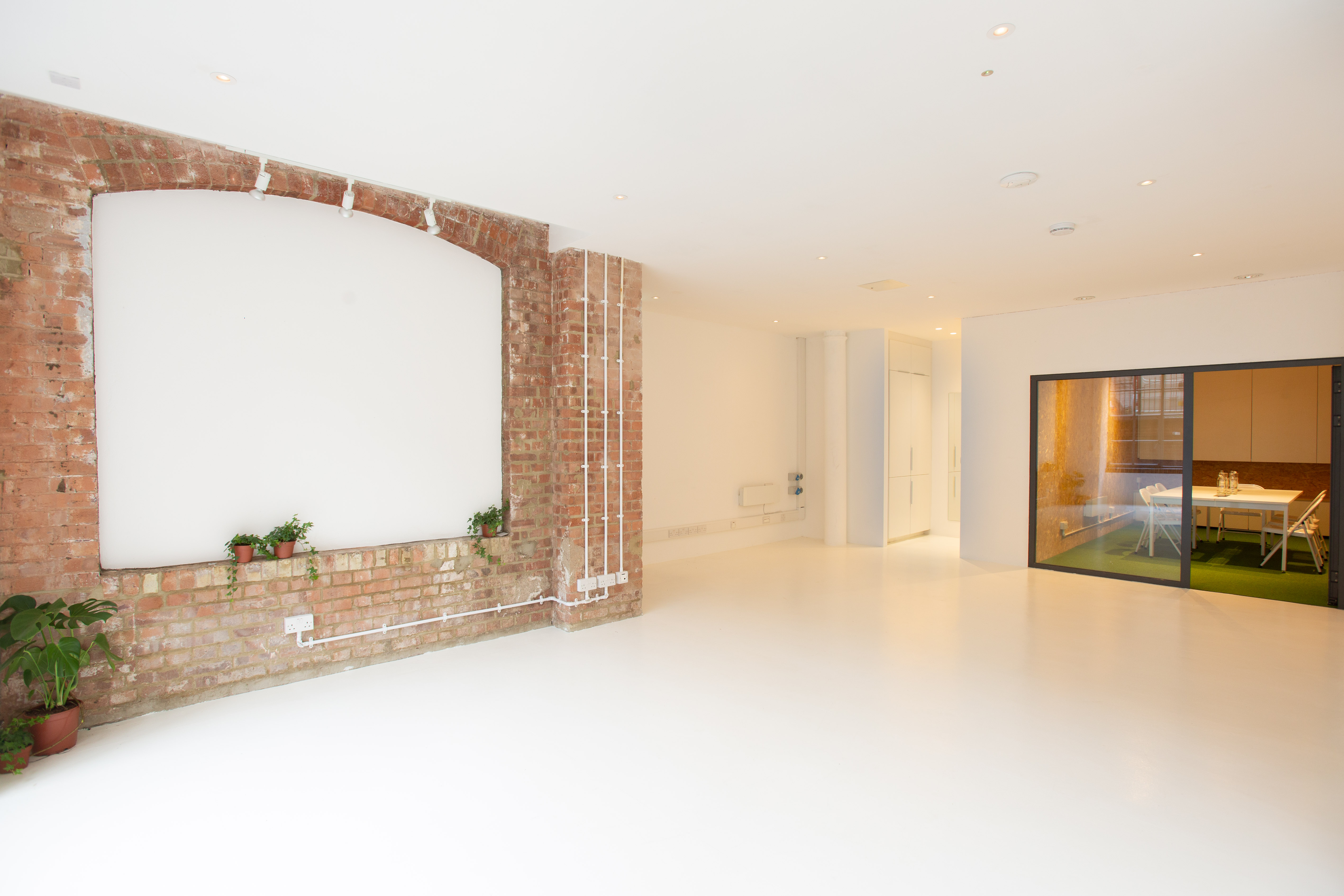 Versatile event space with exposed brick walls, ideal for meetings and creative events.