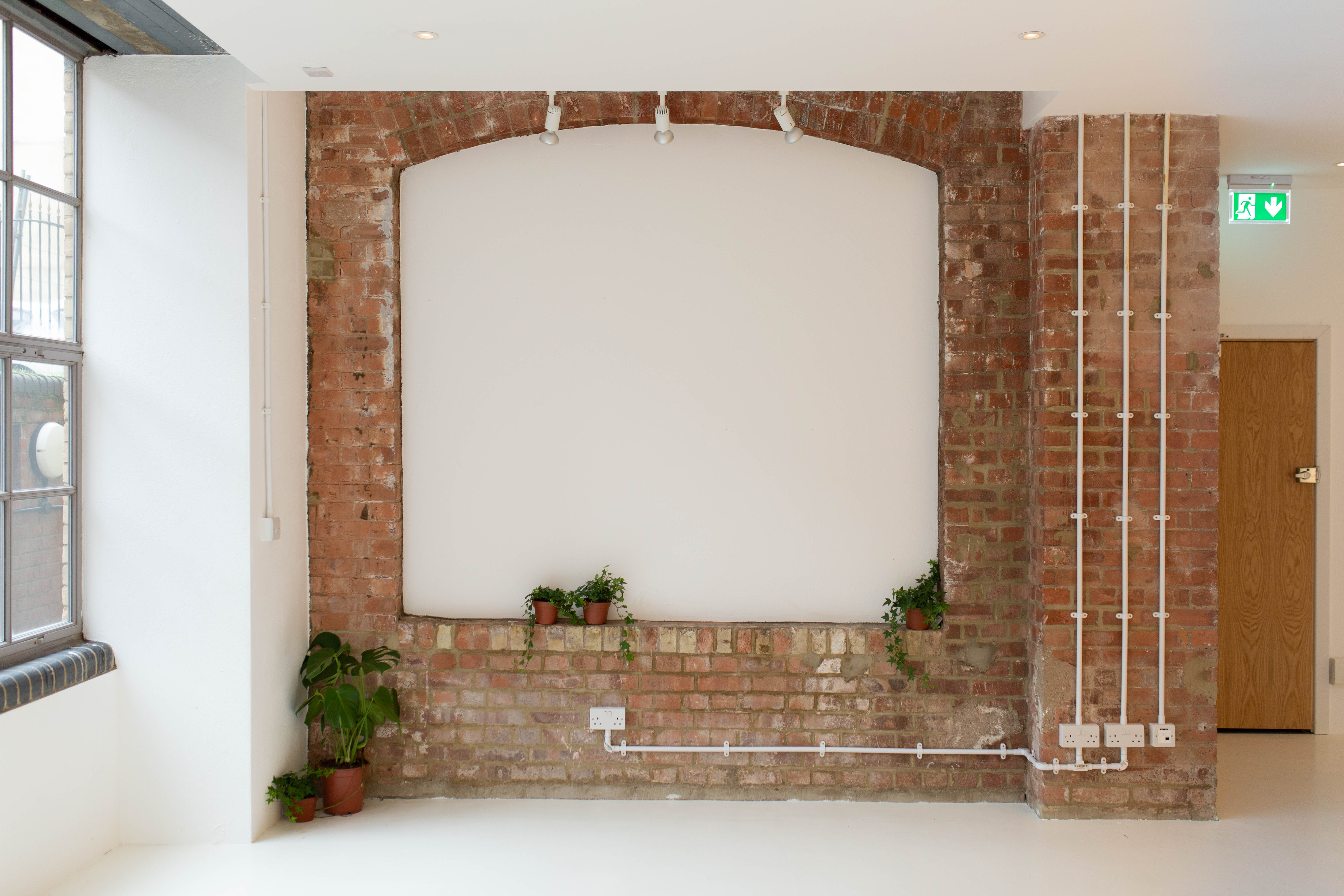 Versatile event space with exposed brick walls, ideal for workshops and meetings.