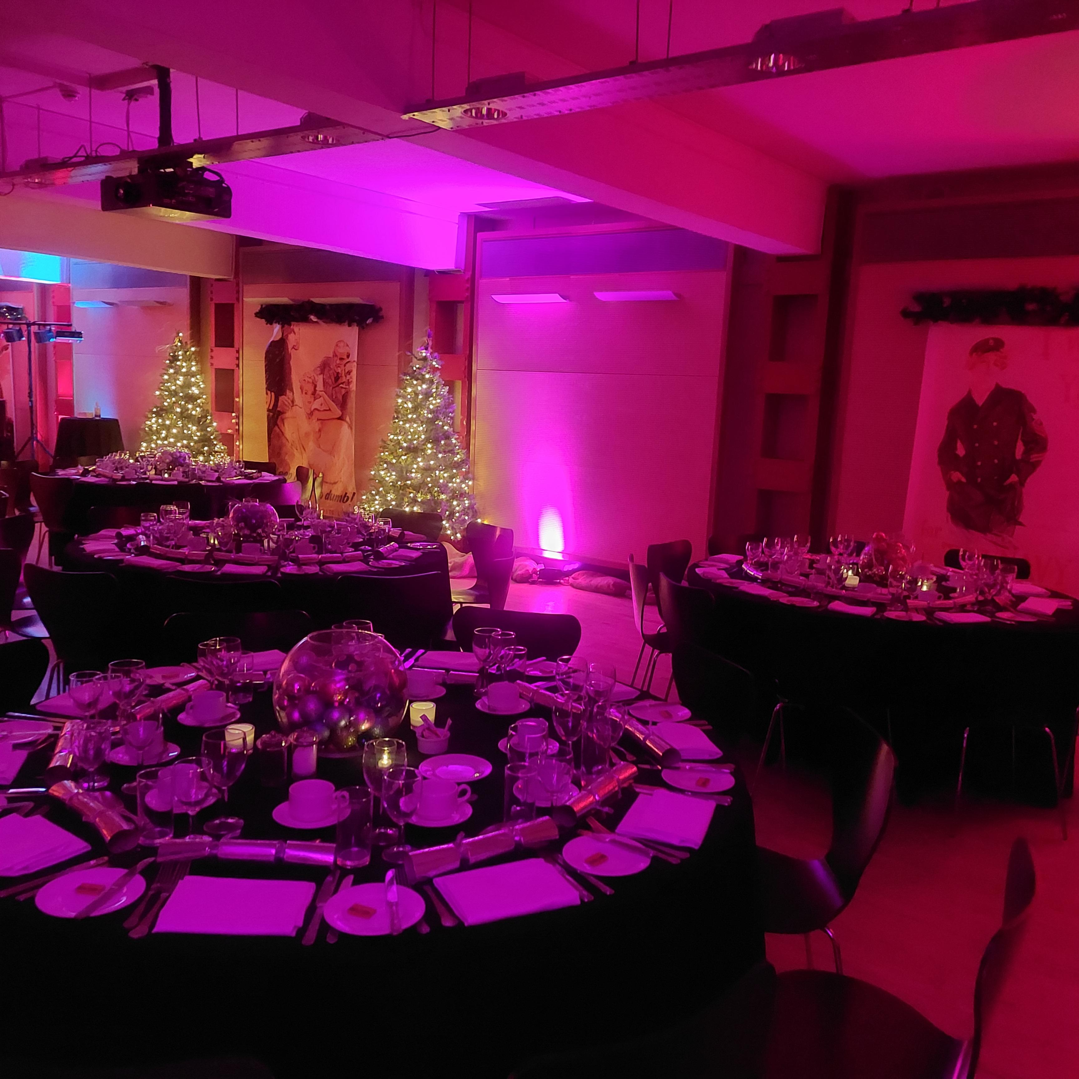 HCA Auditorium with round tables, festive decor for holiday gatherings and corporate events.