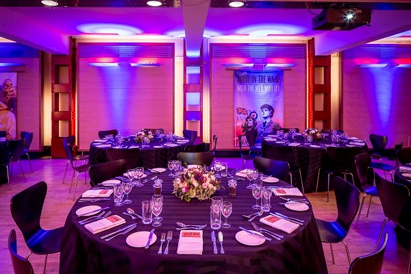 HCA Auditorium set for a formal dinner with elegant tables and ambient lighting.
