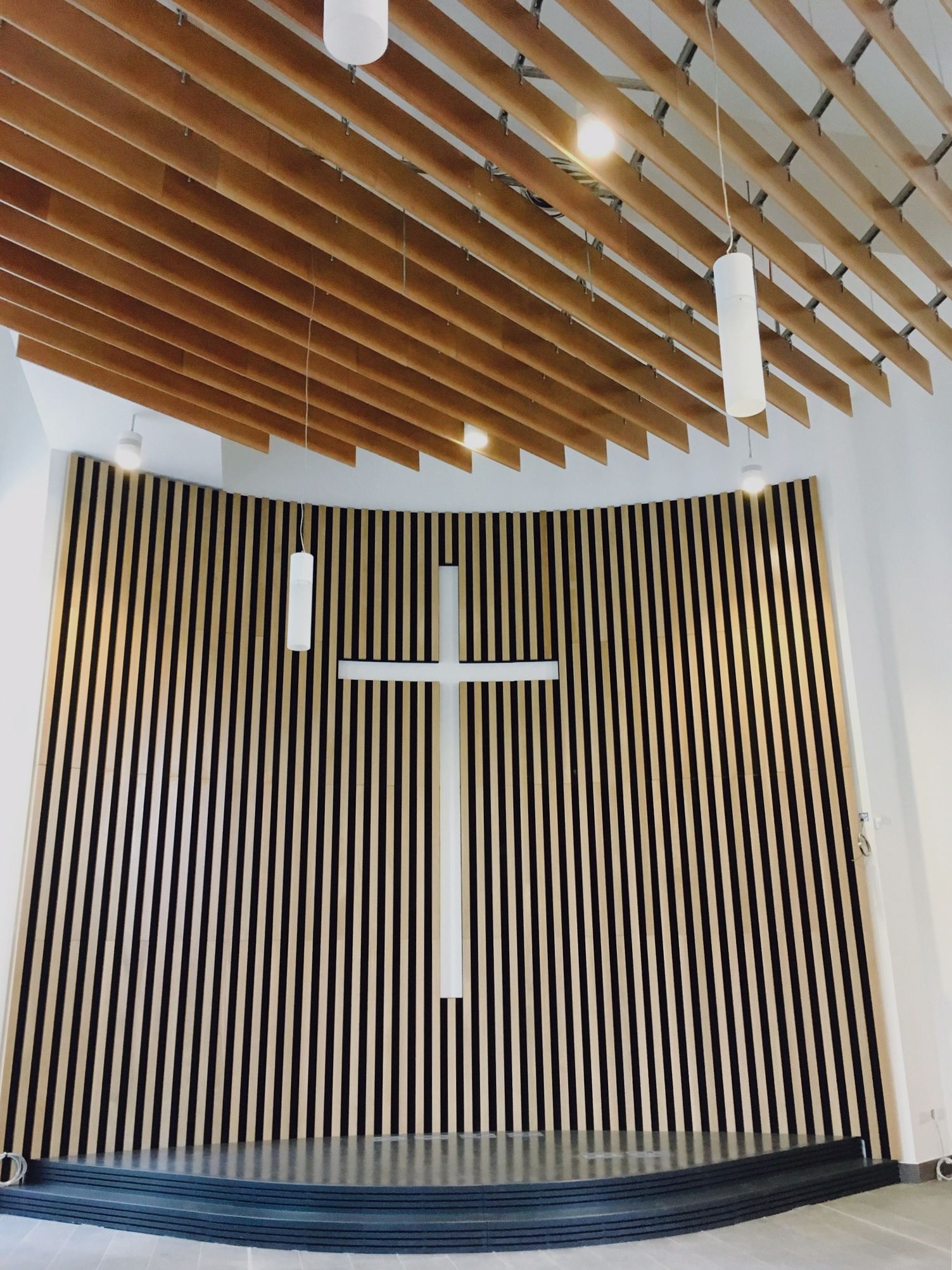 Modern Performance Hall with wooden slat wall, ideal for faith-based events and gatherings.