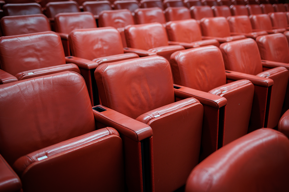Plush red theater seats in Guy Whittle Auditorium for engaging presentations and performances.