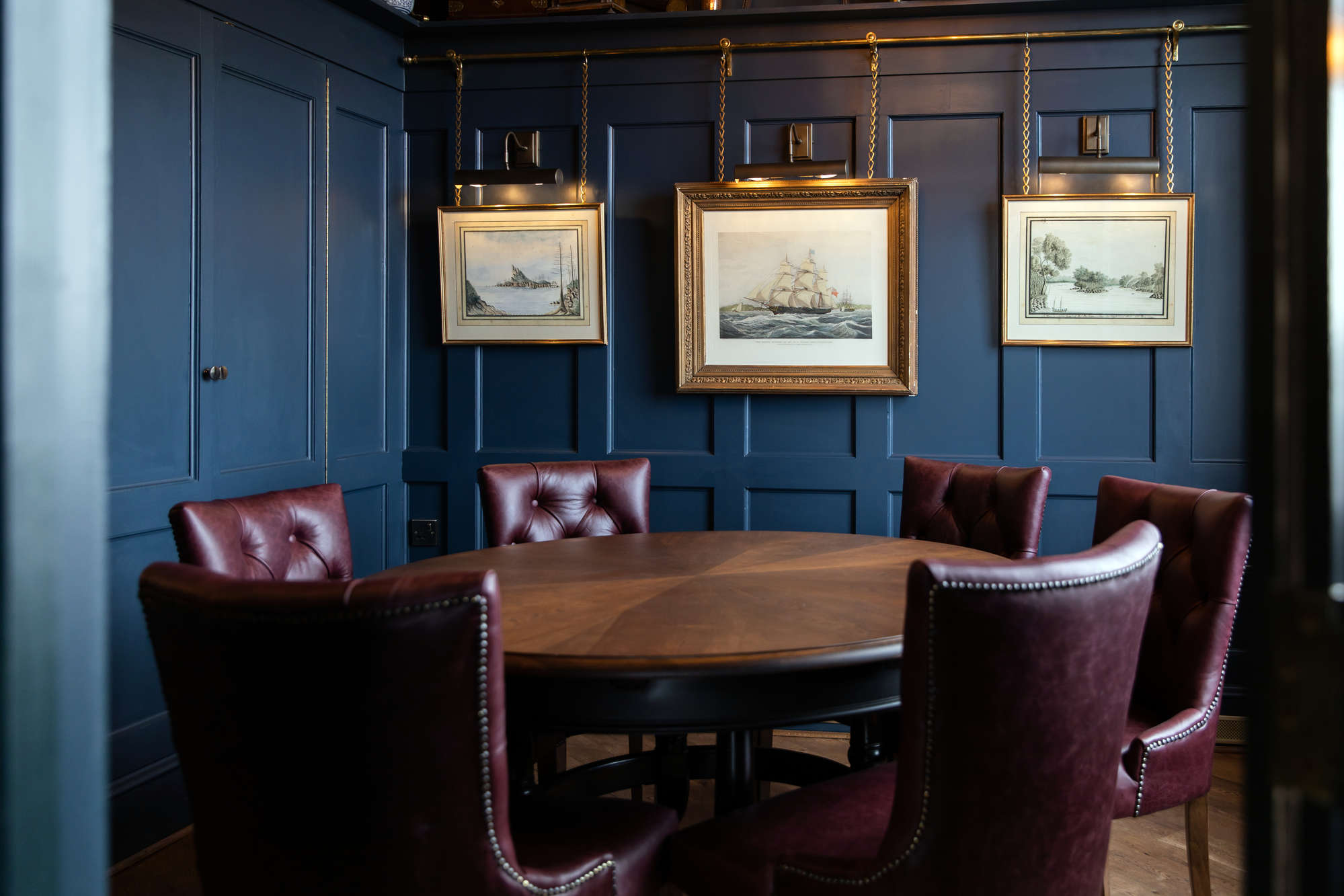 Sophisticated meeting space with round table and plush chairs in Enderby House.