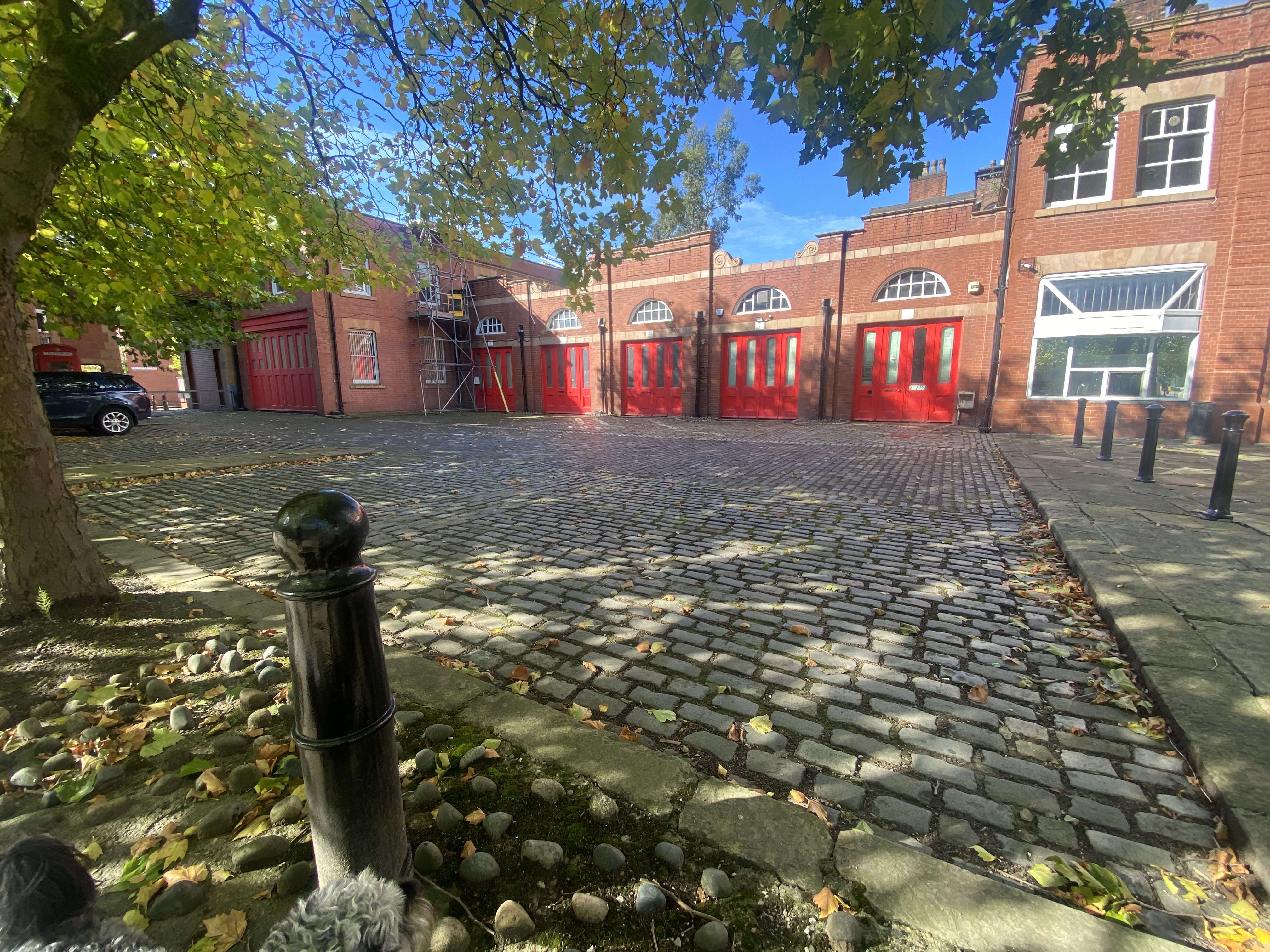Charming outdoor event space at Albert Bentley Place with cobblestone paving and red doors.