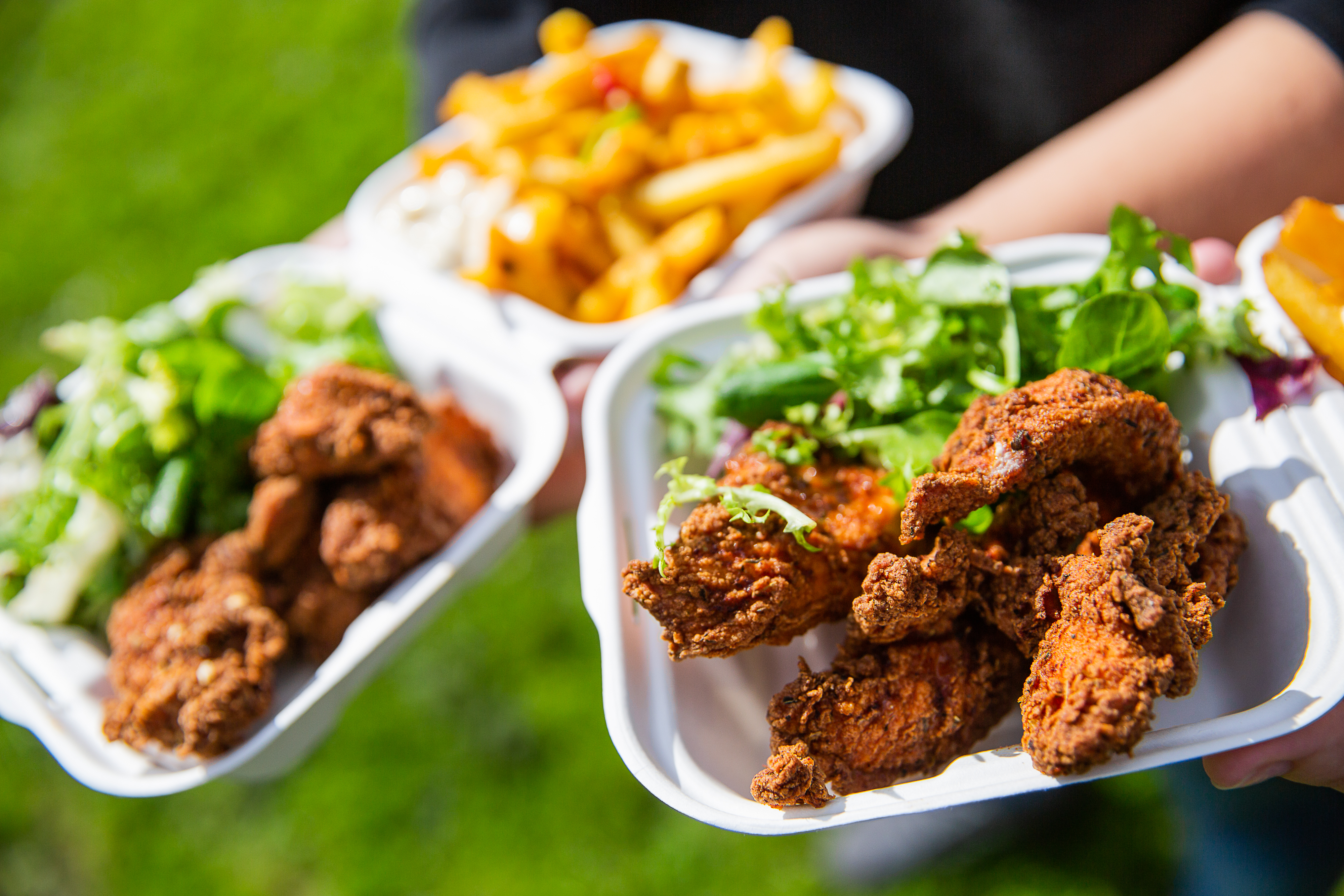 Vibrant outdoor catering setup with fried chicken and salads for successful events.