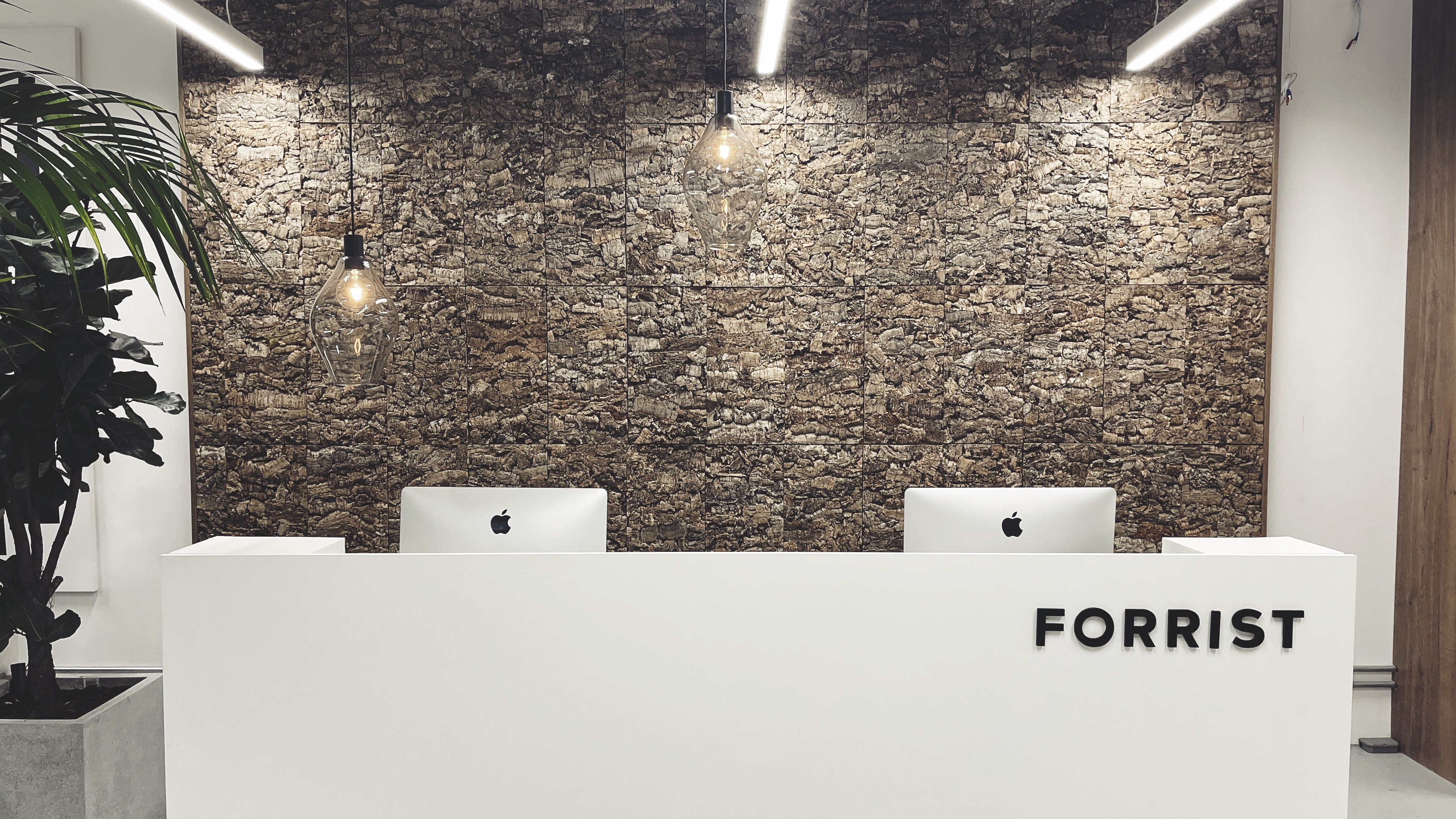 Modern reception area with white desk and Apple computers for corporate events.