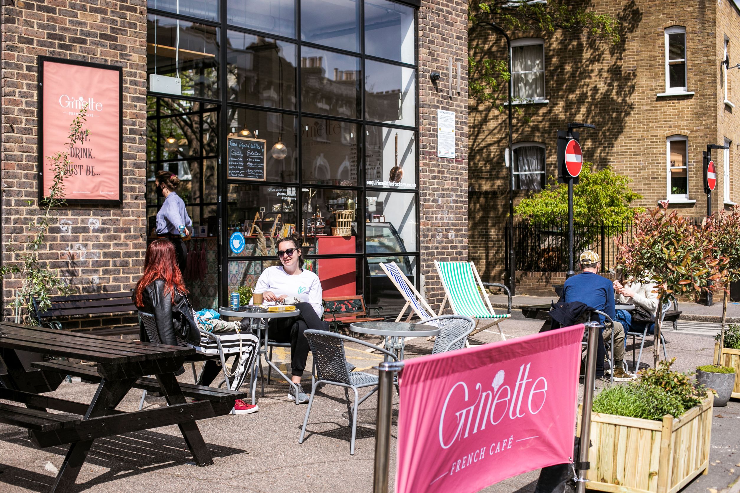 Vibrant outdoor café with greenery, perfect for casual meetings and networking events.