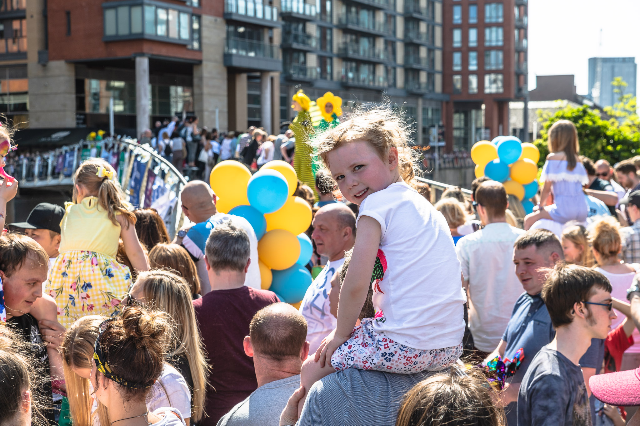 Vibrant outdoor family event in Stanley Square with colorful balloons and community spirit.