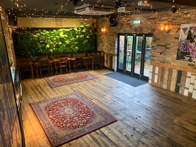 Function Room at The Village Green: versatile event space with wooden flooring, ideal for gatherings.