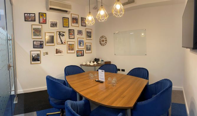 Meeting room at Rylands, featuring a round table and blue chairs for collaborative sessions.