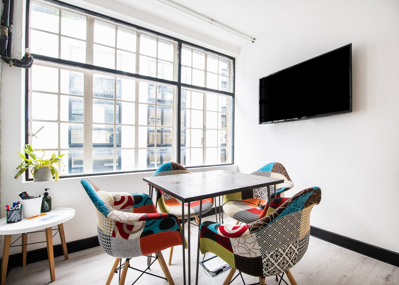 Modern meeting space with stylish table and colorful chairs in Runway East Soho.