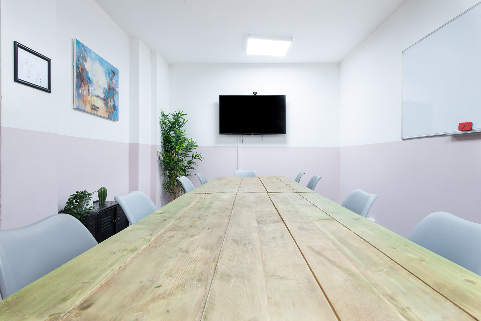 Modern meeting room with large wooden table at Runway East Soho for collaborative events.