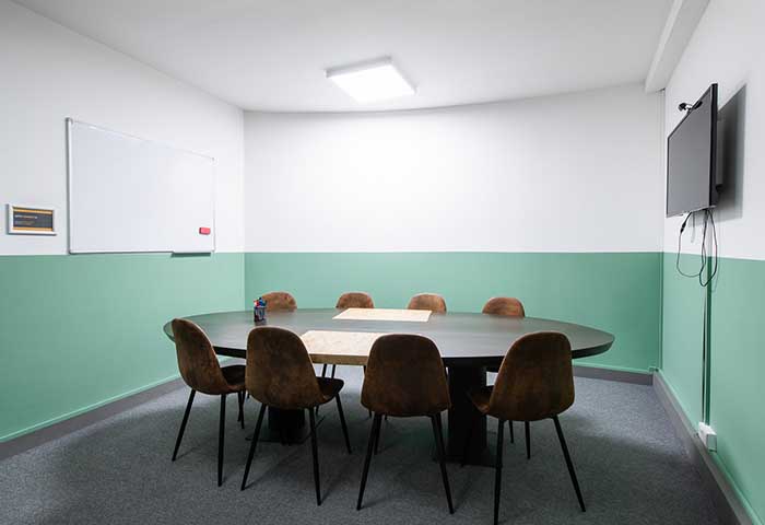 Modern meeting room in Runway East Soho with oval table, ideal for collaborative sessions.