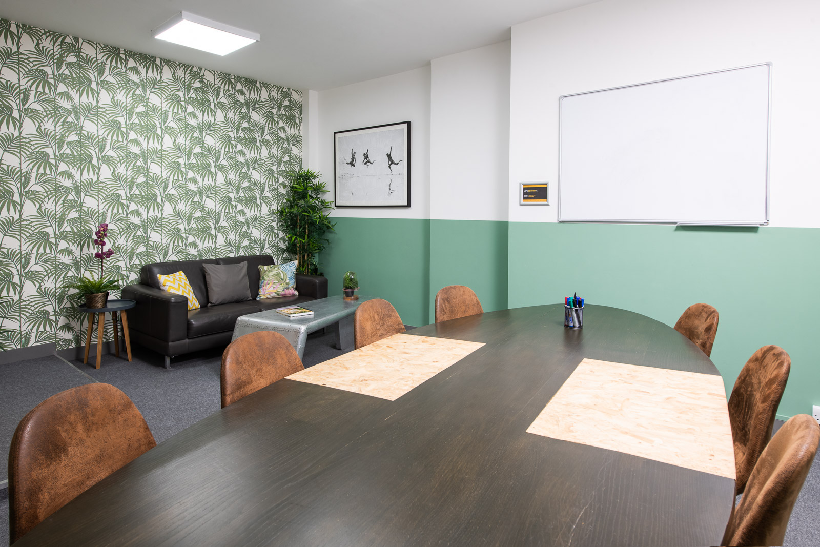 "Meeting room in Runway East Soho with round table, greenery for creative collaboration."