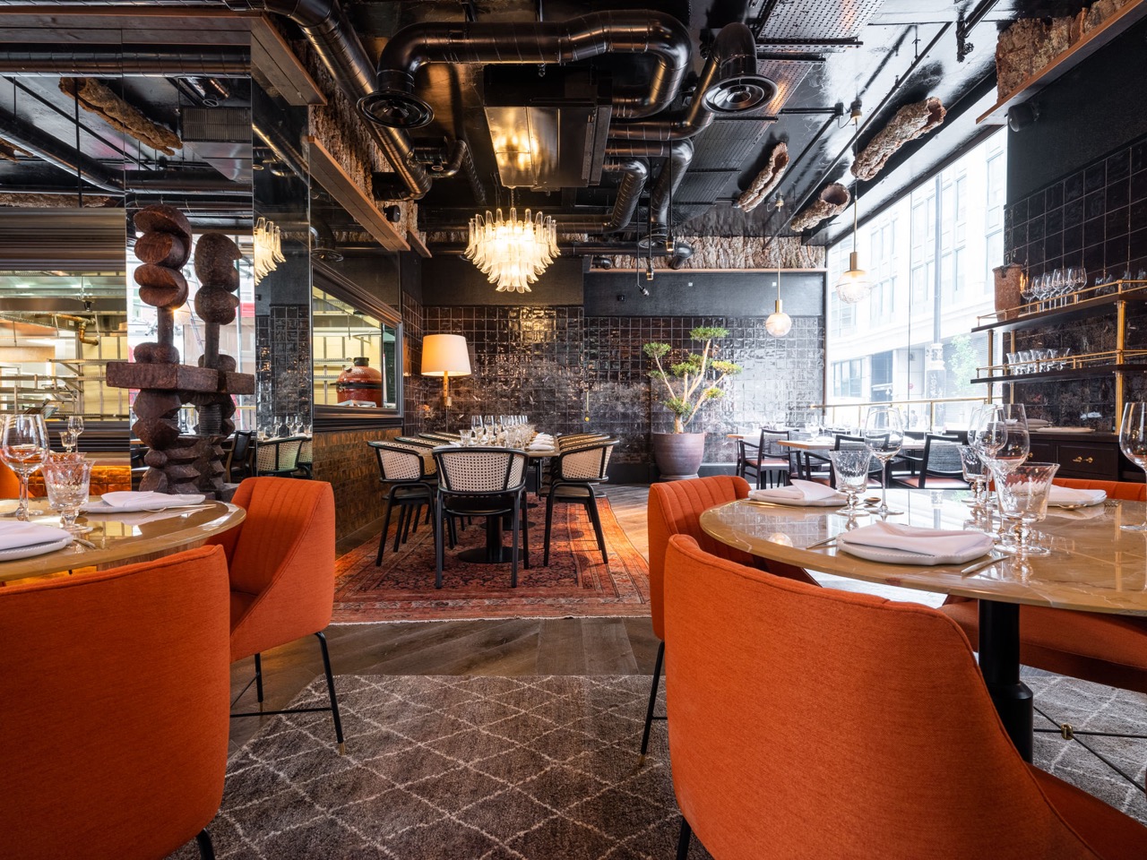 Stylish dining room at Arros QD with warm orange chairs for intimate events.