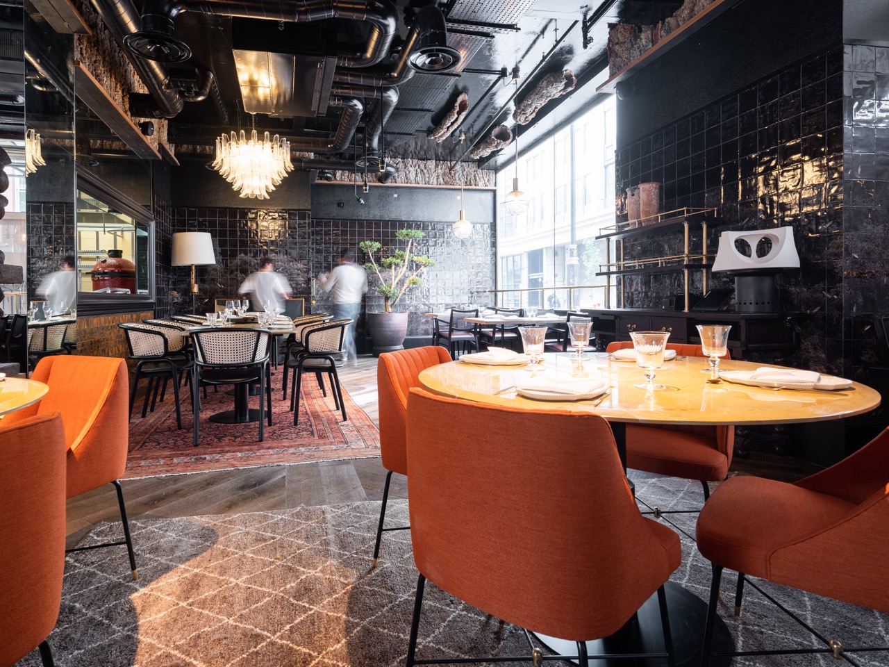 Modern dining room at Arros QD with warm orange chairs, ideal for corporate dinners.