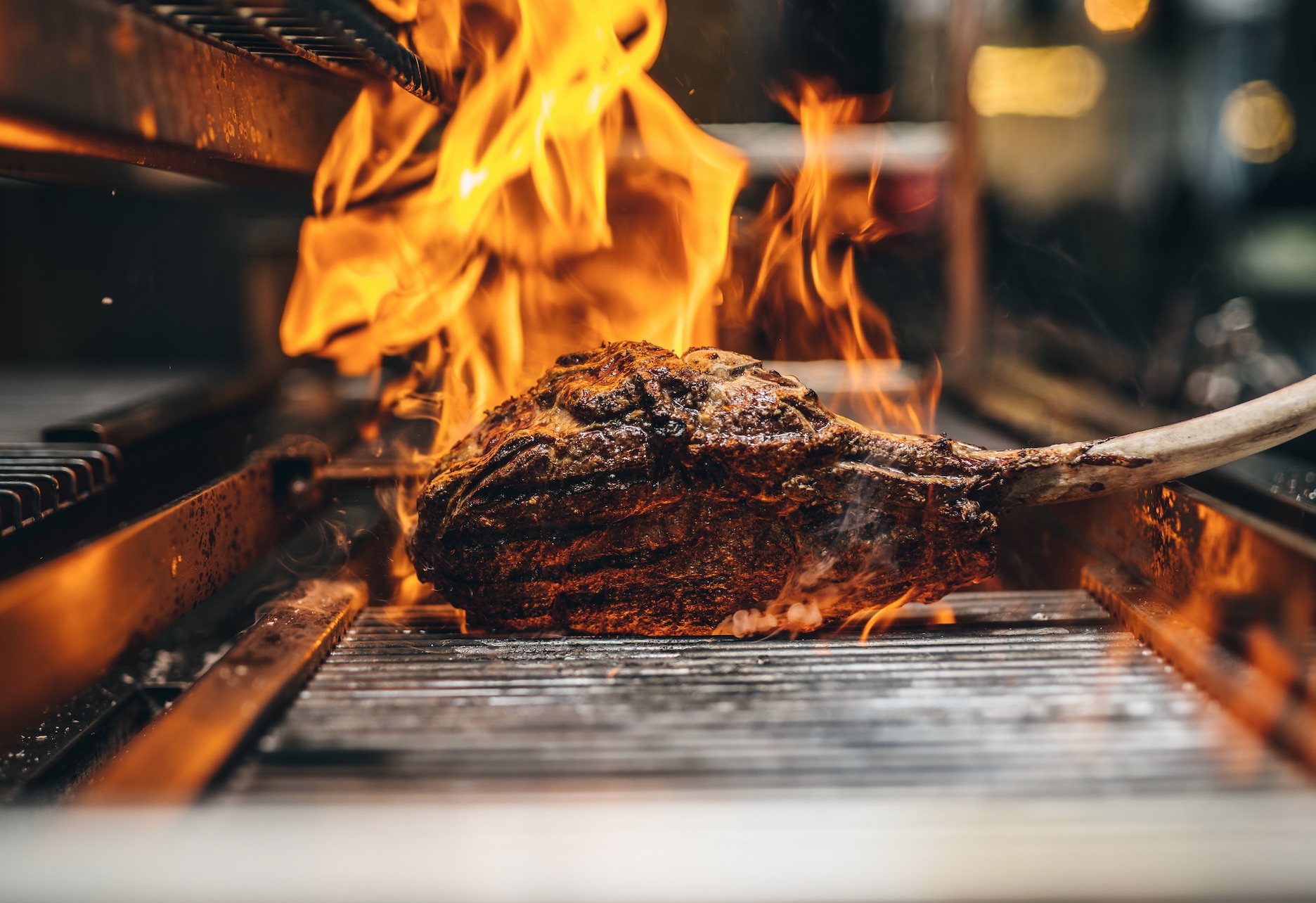 Grilled meat over open flame at Arros QD, perfect for upscale events and barbecues.