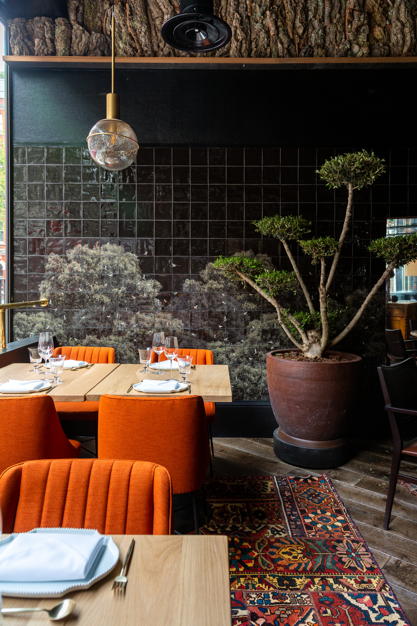 Stylish dining area in Arros QD with warm orange chairs for intimate events.