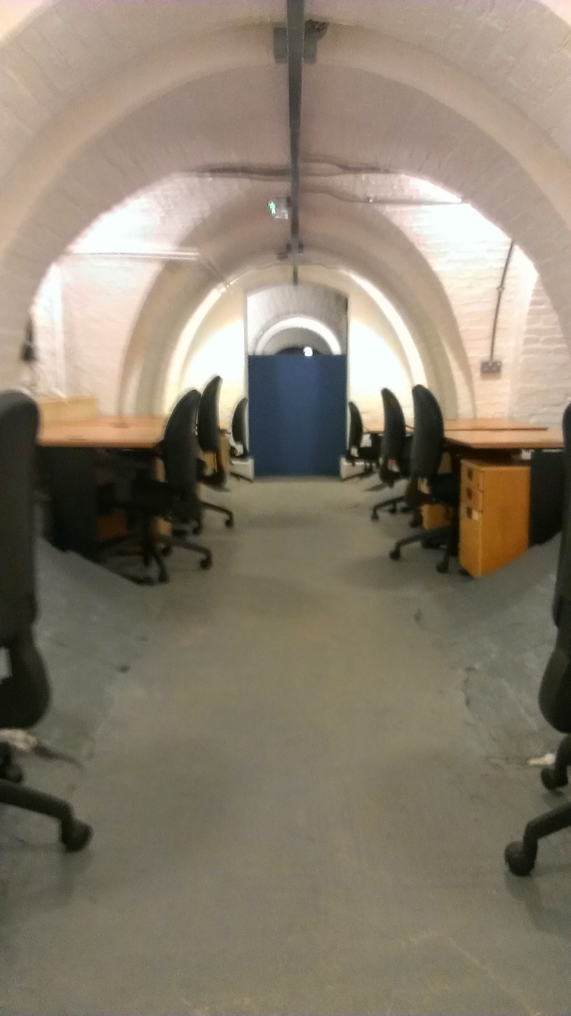 SpacE2 meeting space with ergonomic chairs and brick walls for creative workshops.