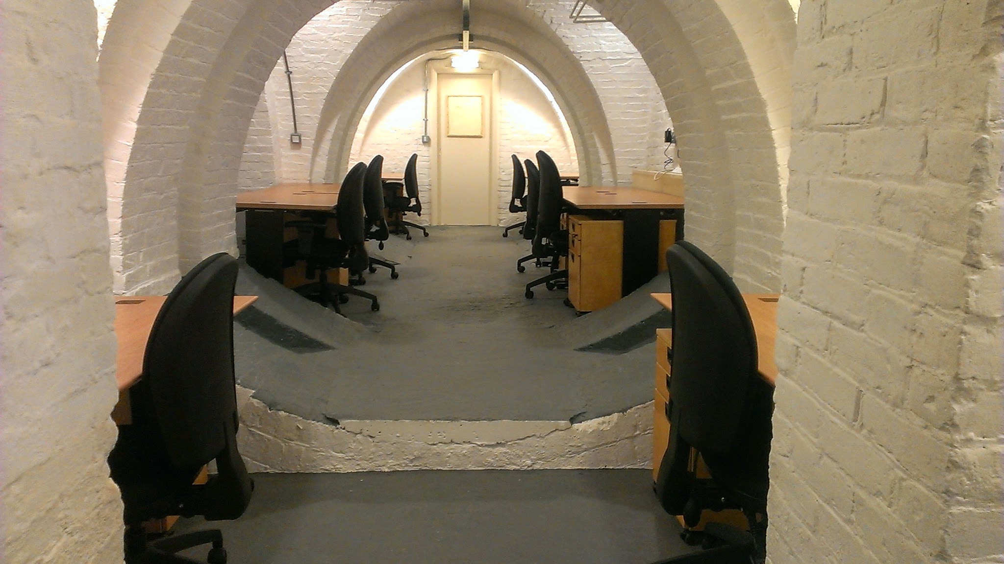 SpacE2 meeting space with arched brick design, ideal for events and workshops.