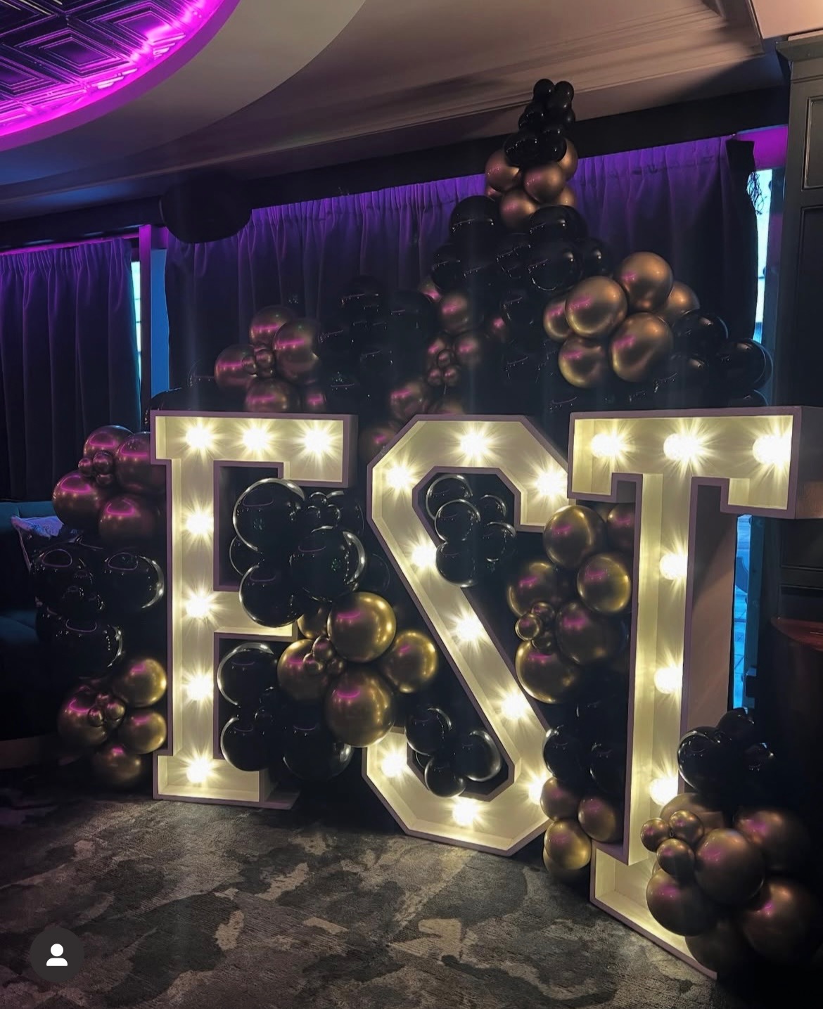 Vibrant event setup with "E & T" letters and black-gold balloons at BLVD Spinningfields.