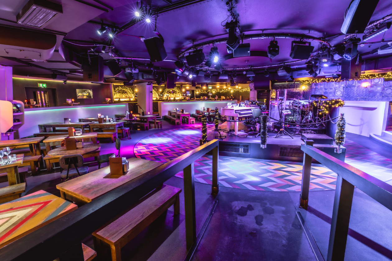 Vibrant event space with stage and colorful lighting for corporate and social gatherings.