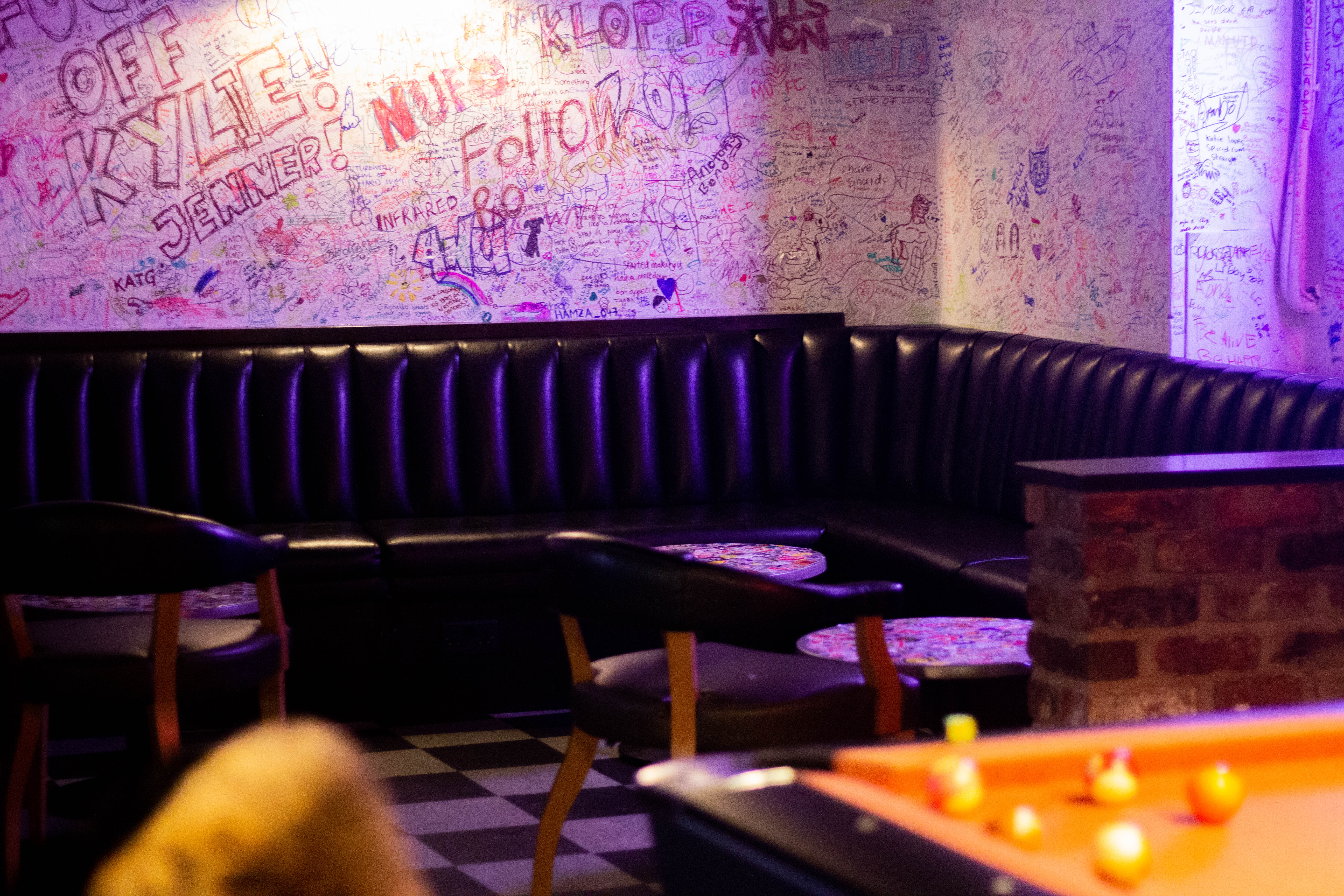 Vibrant meeting space with leather booth and graffiti, ideal for networking events in Manchester.