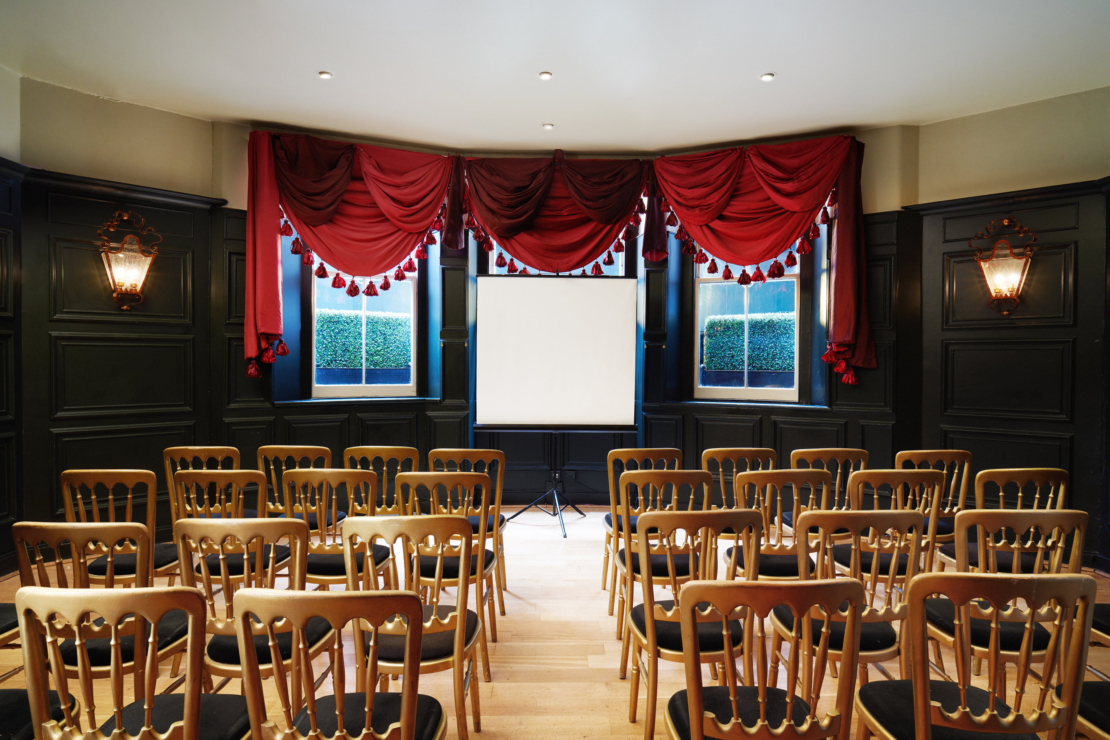 Elegant meeting room with red drapery, perfect for workshops and small conferences.