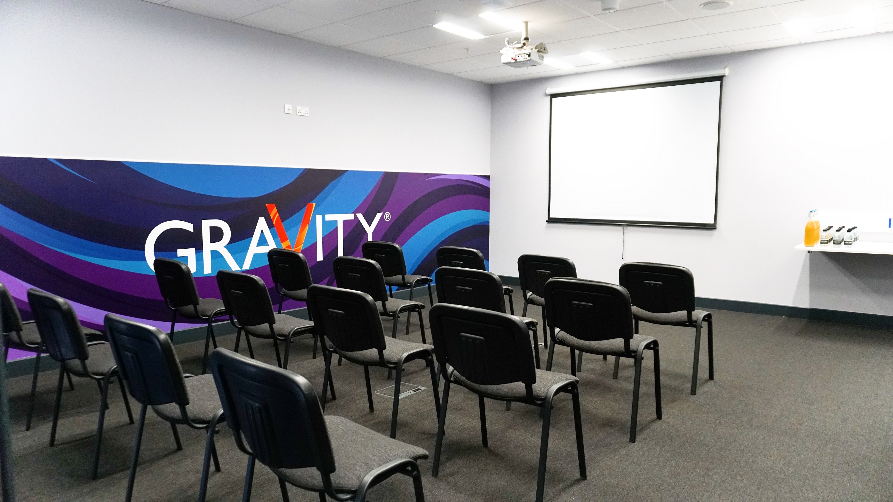 Meeting room at Gravity Wandsworth with vibrant branding for workshops and presentations.
