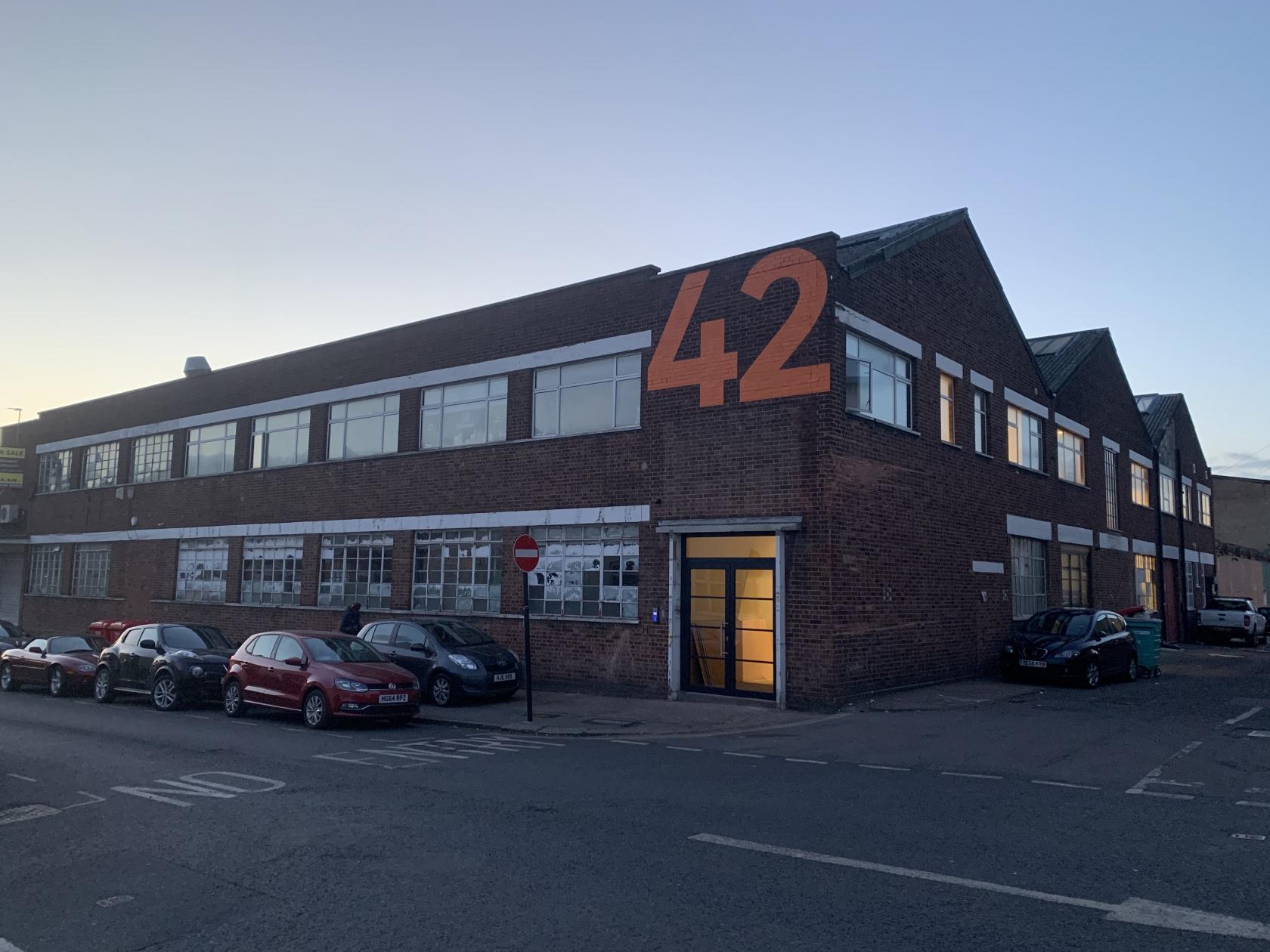 Creative studio space with large windows, ideal for meetings and workshops.