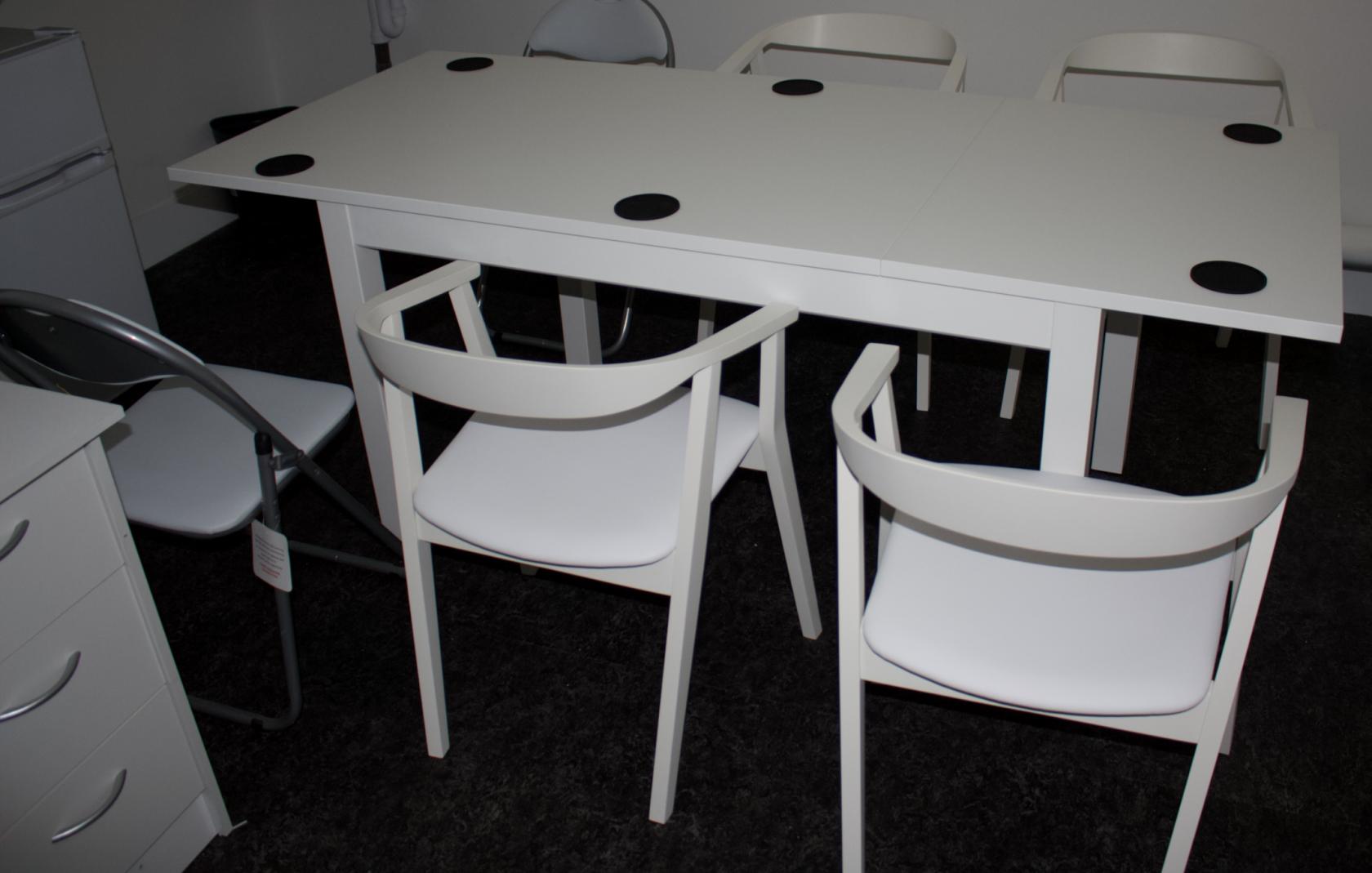Minimalist podcast meeting room with white table, ideal for brainstorming sessions.