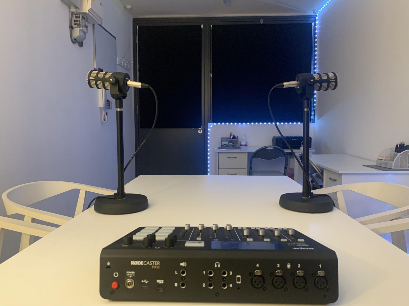 Modern podcast meeting room with professional microphones for quality audio production.