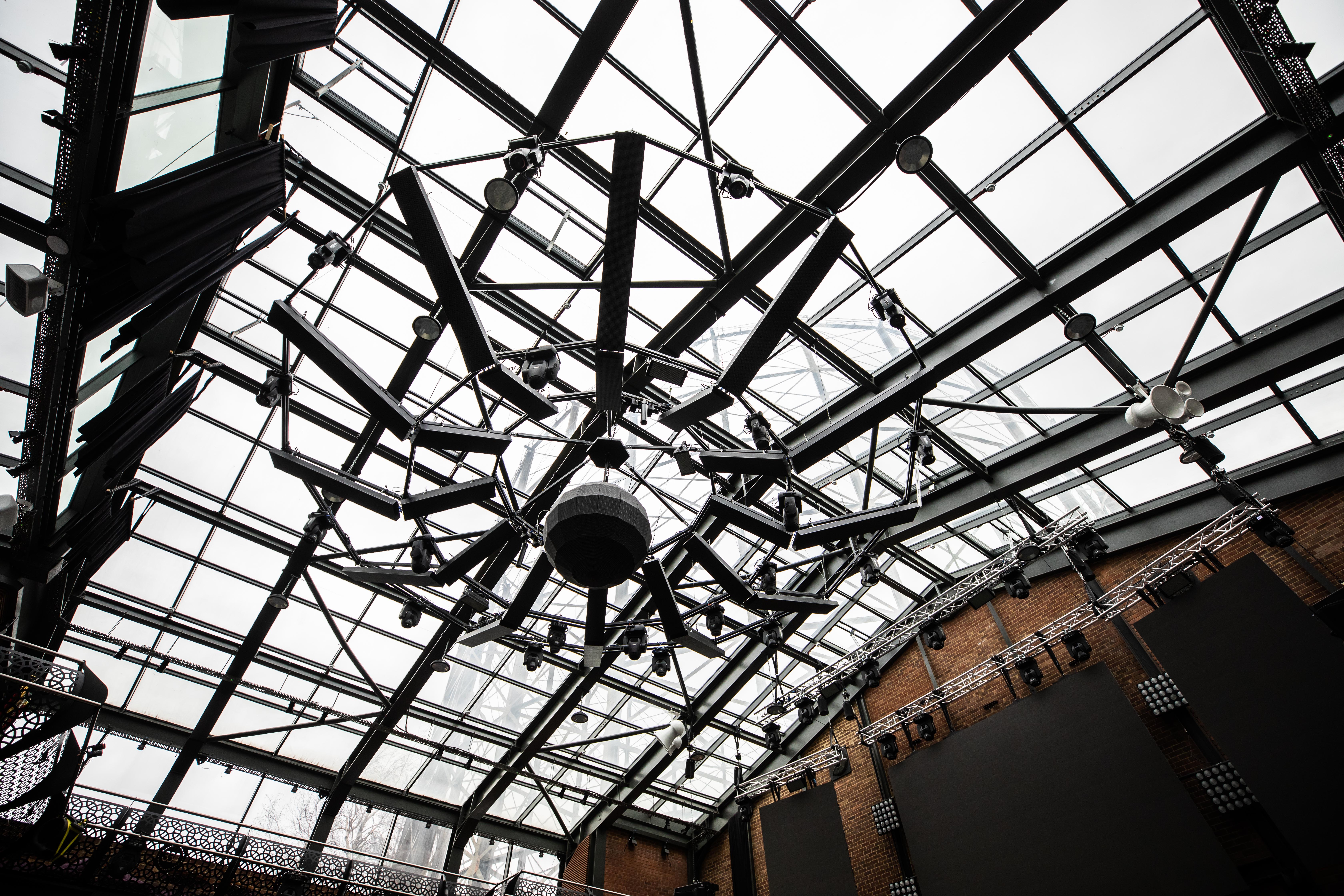 Modern event space with glass ceiling and chandelier at Studio 338, perfect for gatherings.