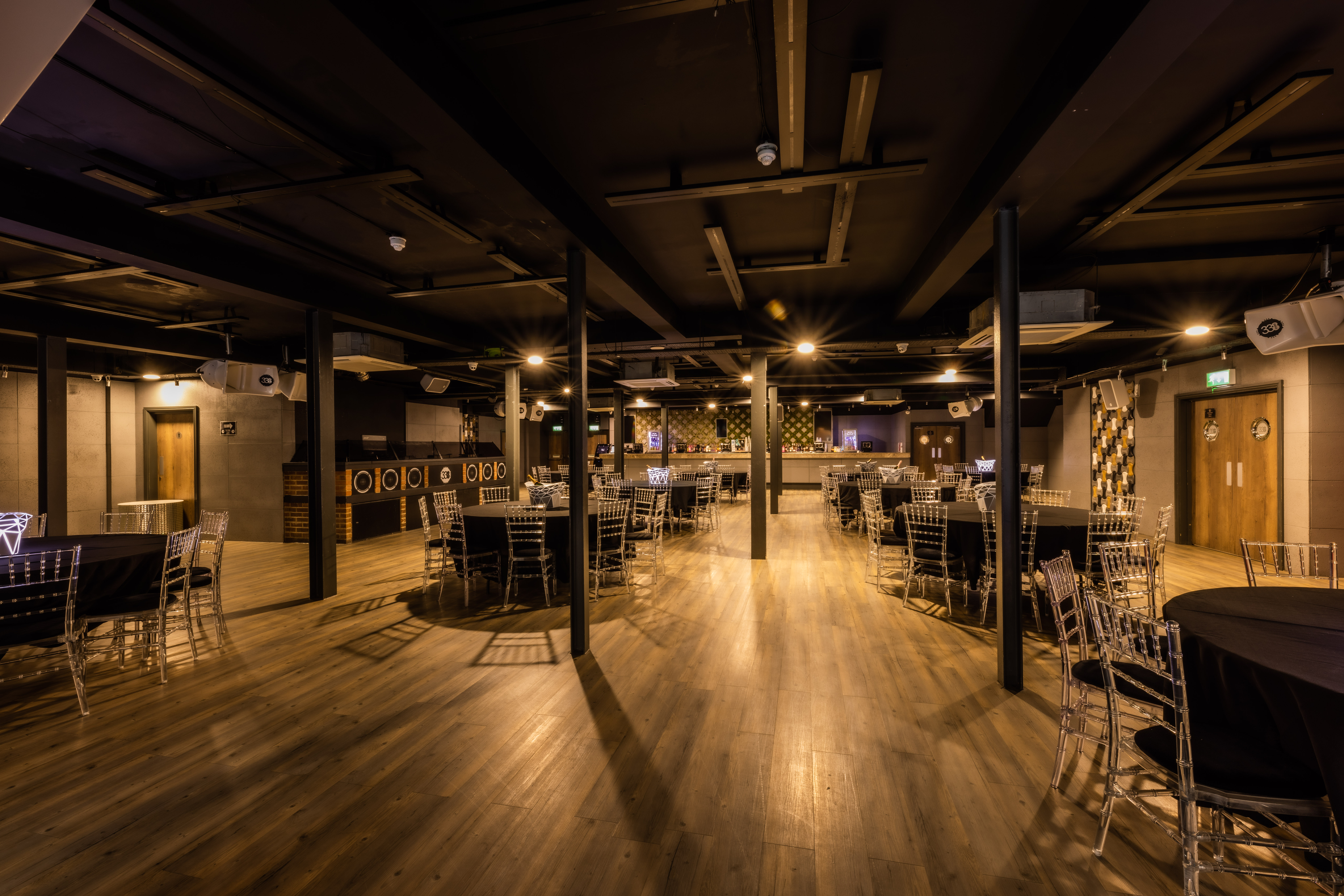 Modern event space with wooden flooring at Studio 338 for meetings and banquets.