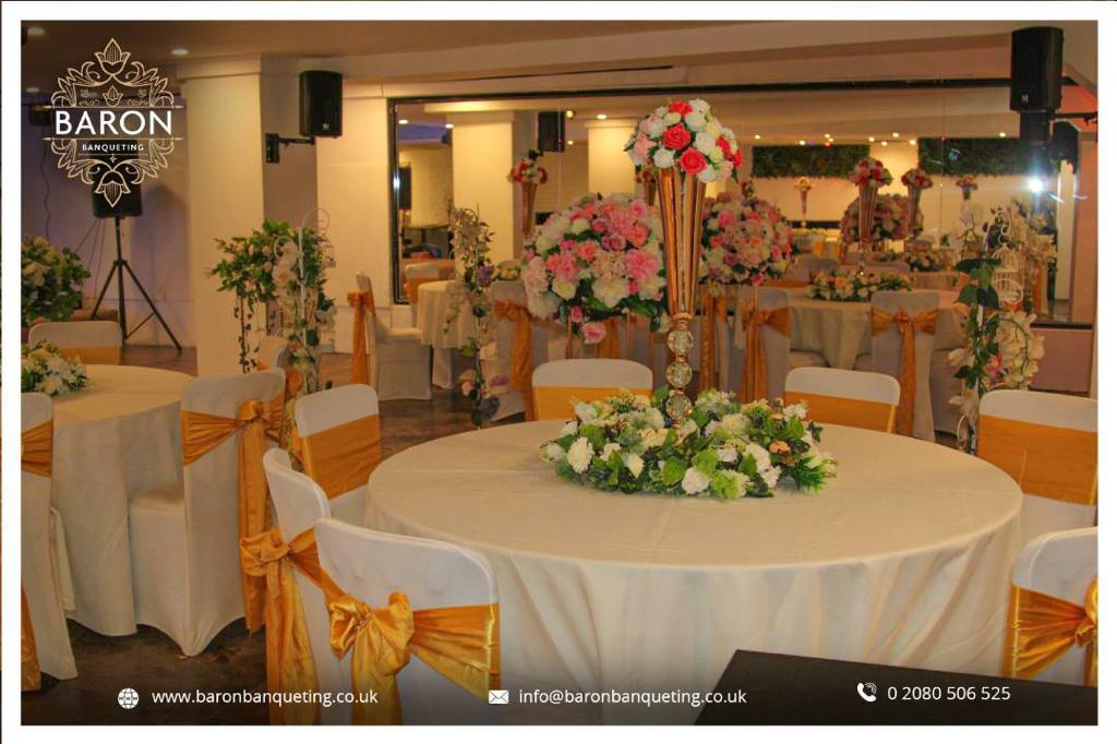 Elegant banquet hall with white linens and gold accents for weddings and corporate events.