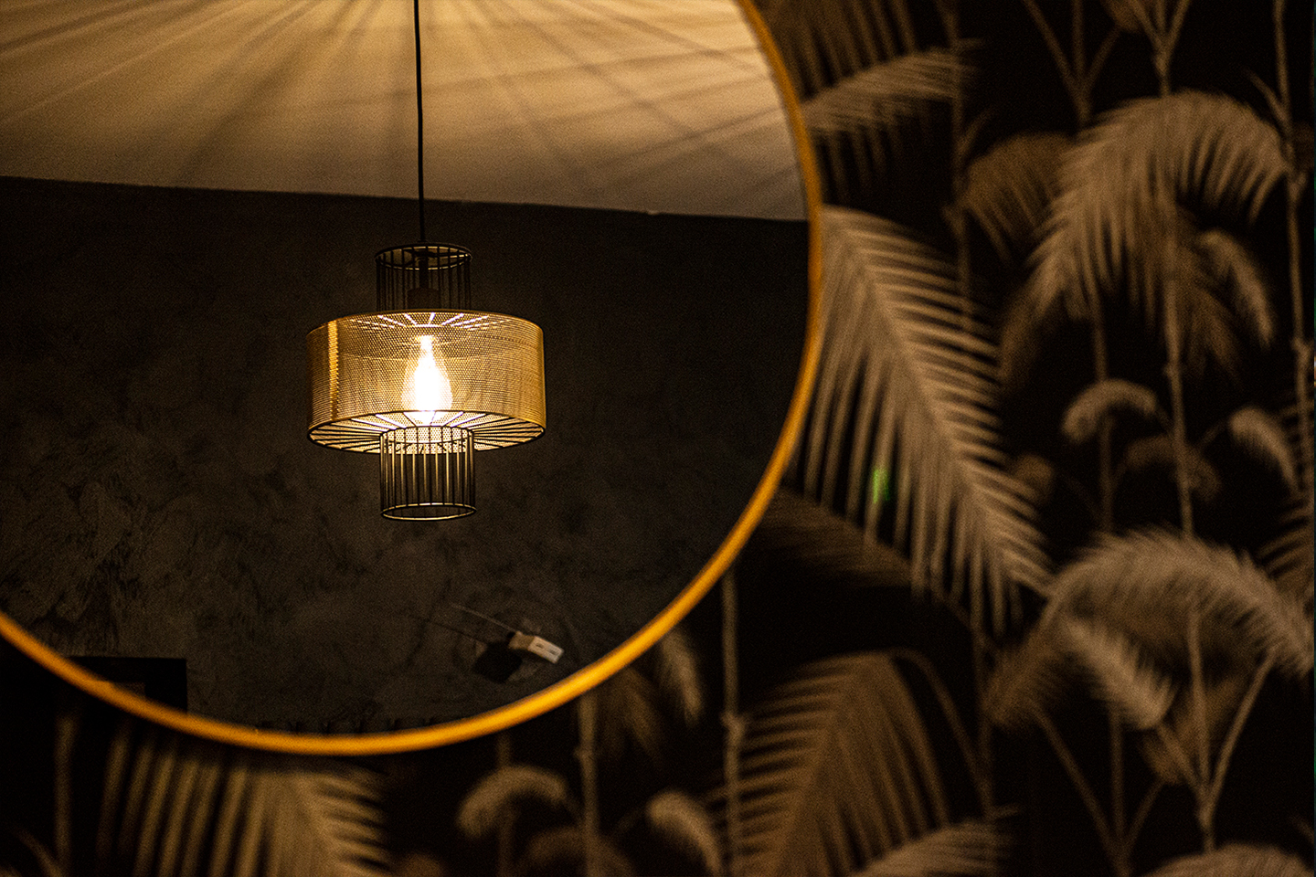 Stylish pendant light in Yours London private dining room with palm leaf wallpaper.