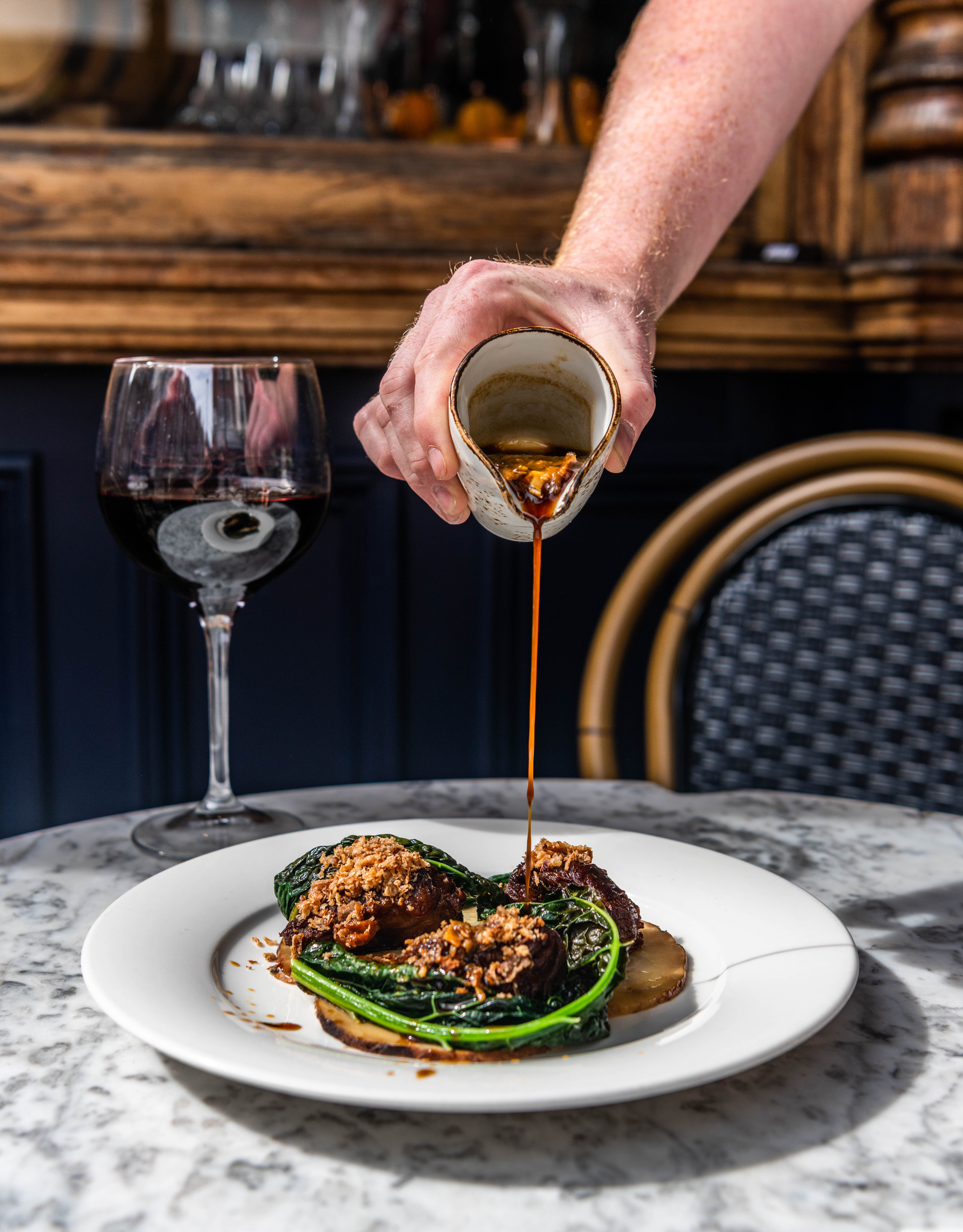 Elegant dish with rich sauce and red wine at The Lounge, perfect for events and dining.