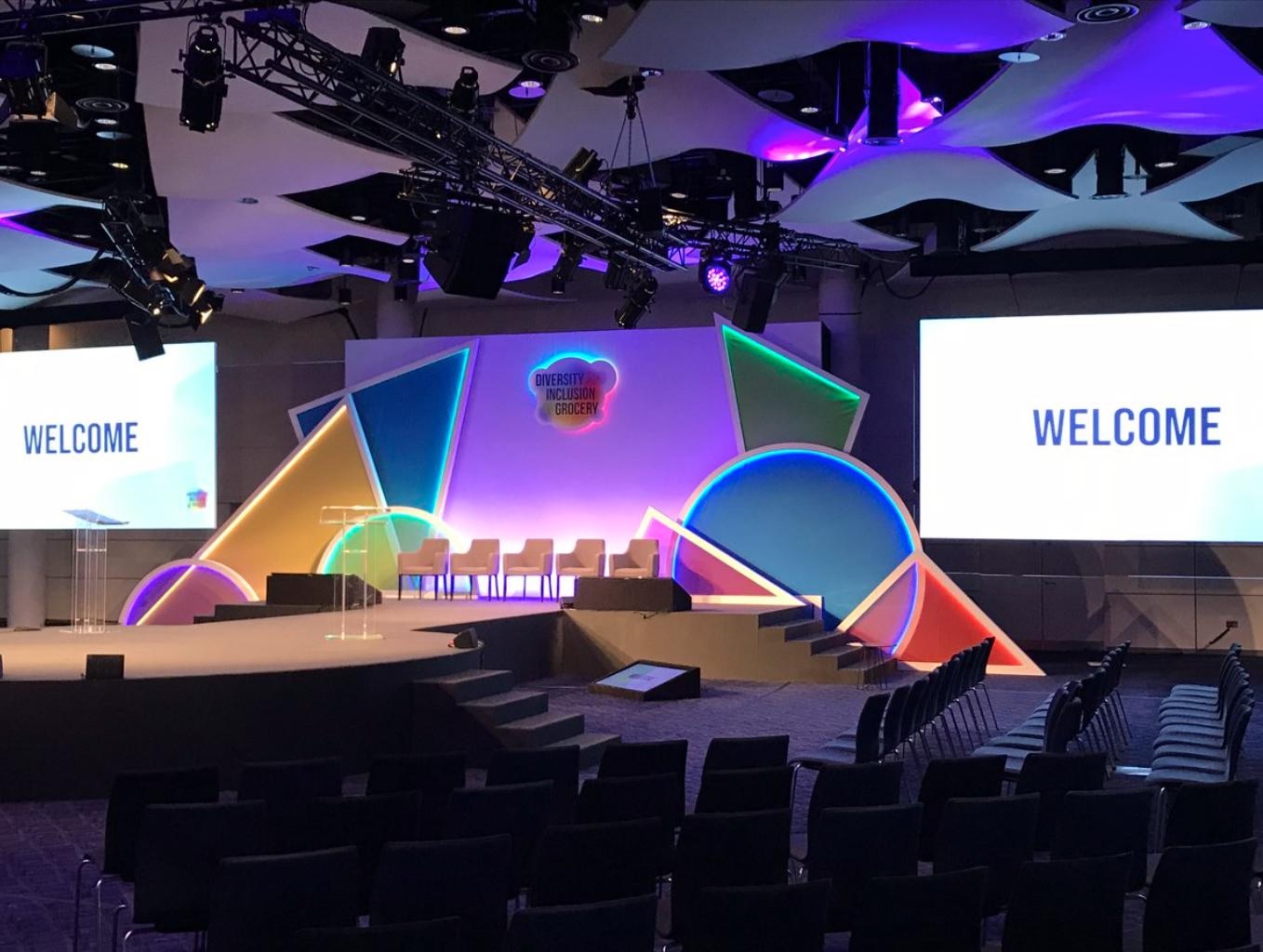 Wembley Stadium Great Hall set for a vibrant conference with colorful stage design.