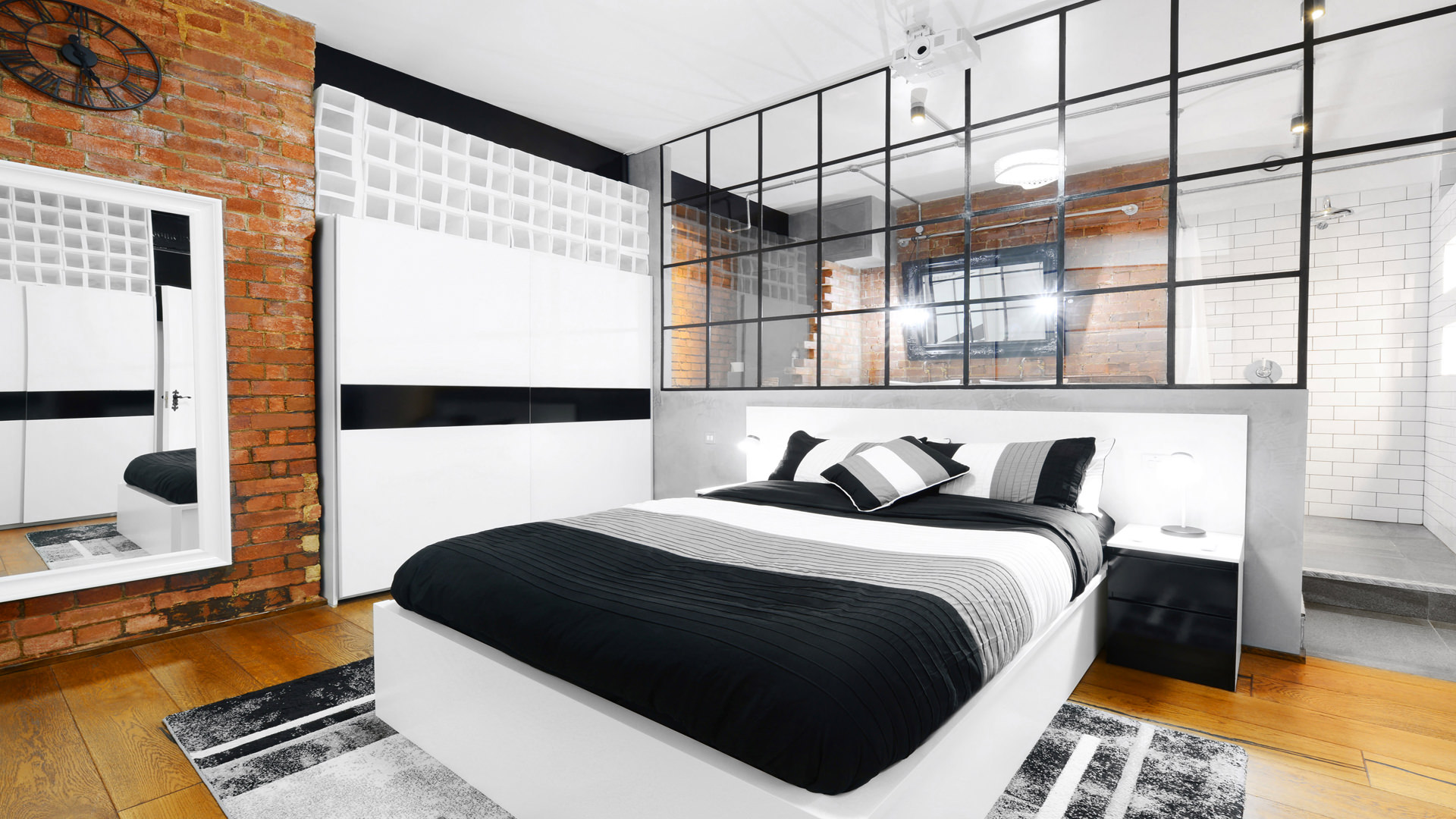 Modern bedroom in S1 Apartment, featuring brick walls for upscale events and retreats.