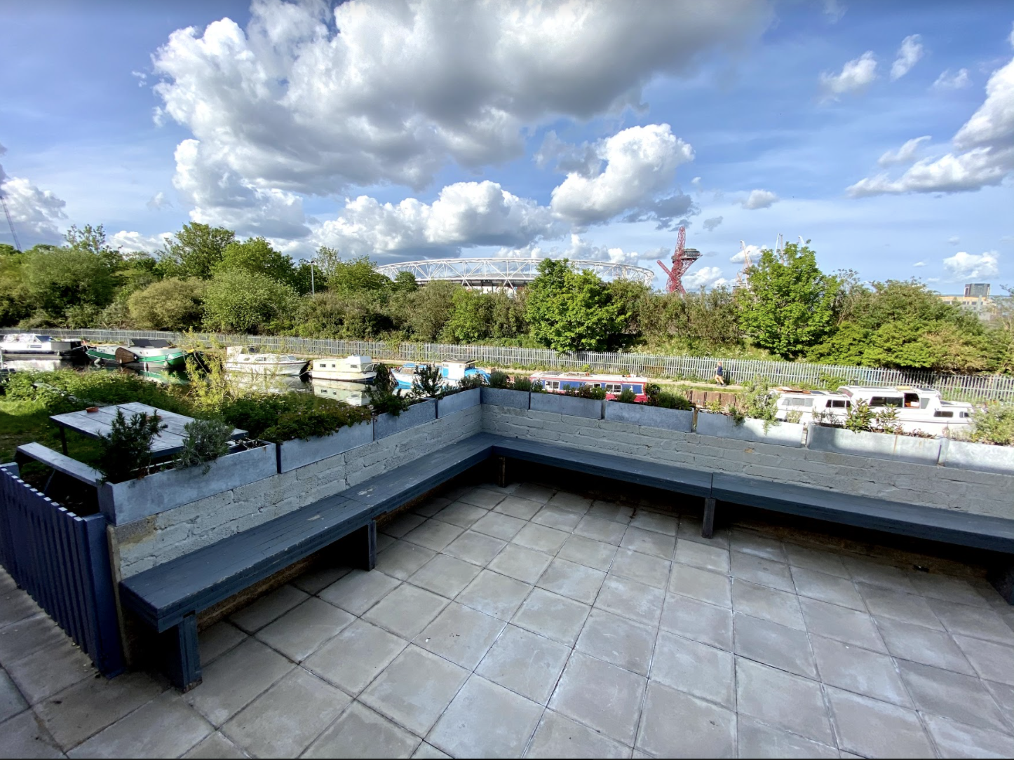 Spacious outdoor terrace with modern seating for networking events by a tranquil canal.