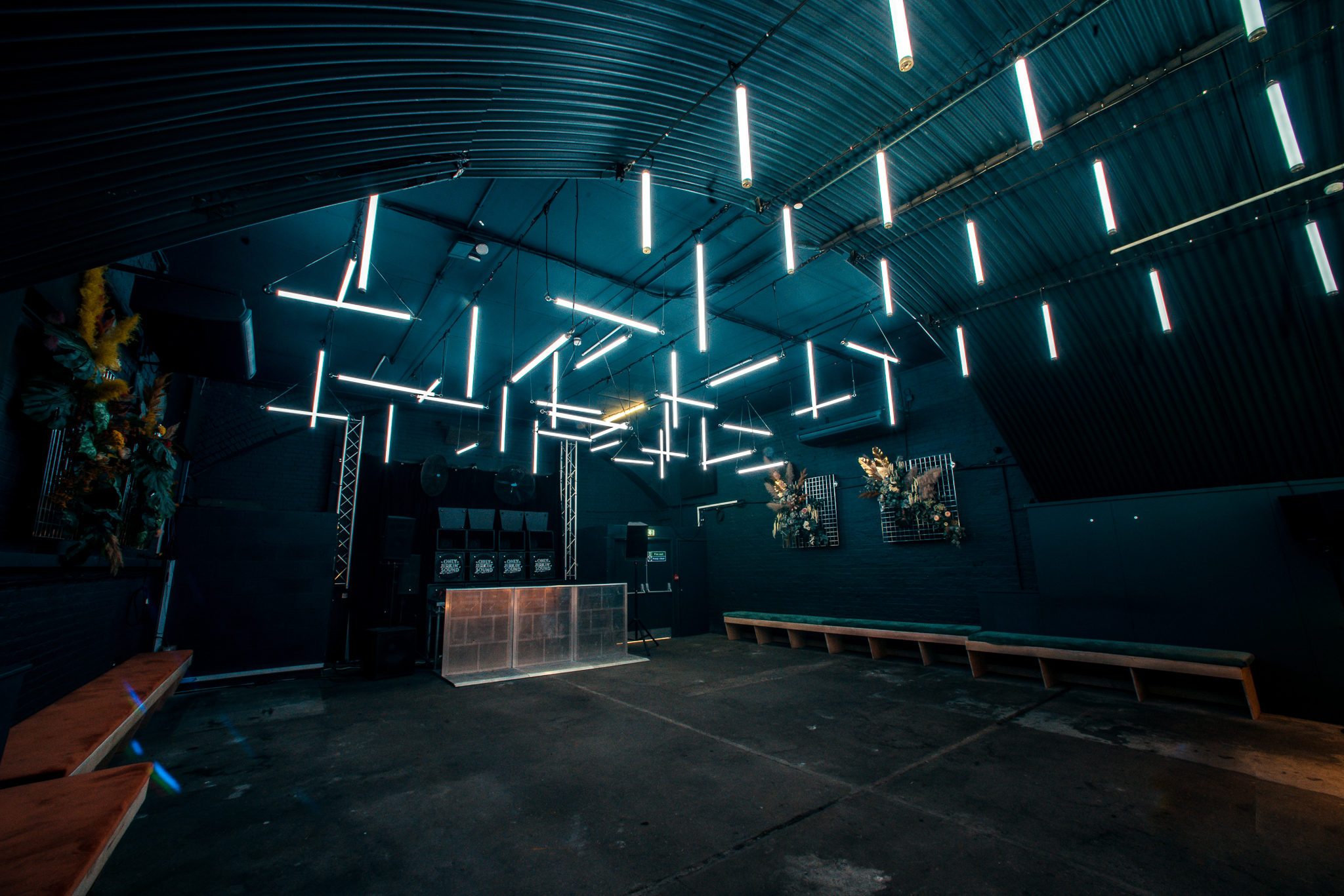 Modern industrial event space with linear lighting for gatherings and celebrations.