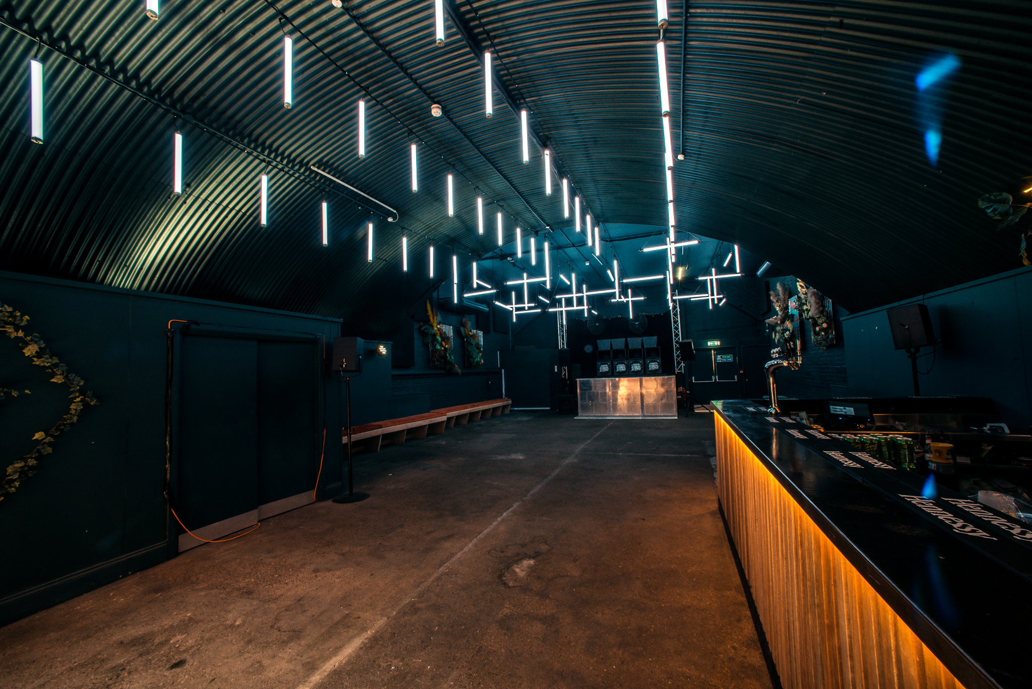 Modern industrial event space with sleek lighting, ideal for parties and networking.