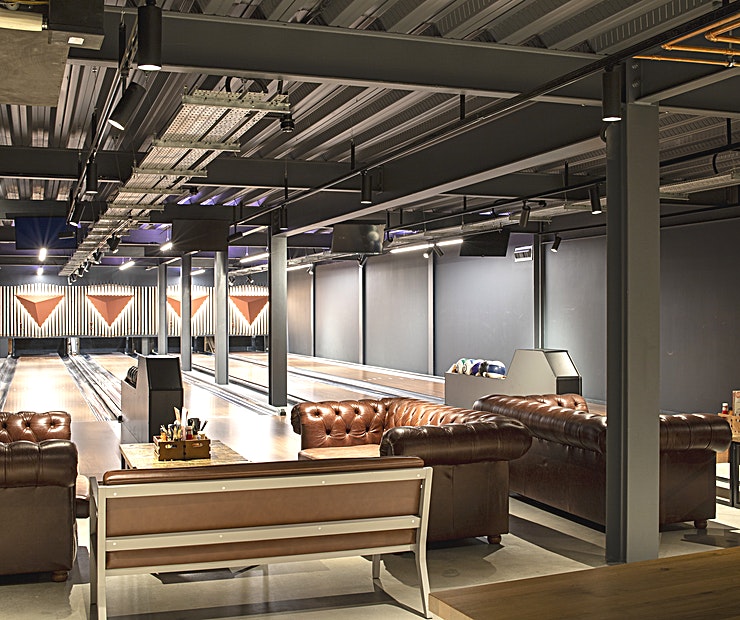 Stylish bowling alley with leather seating for corporate events and team-building activities.