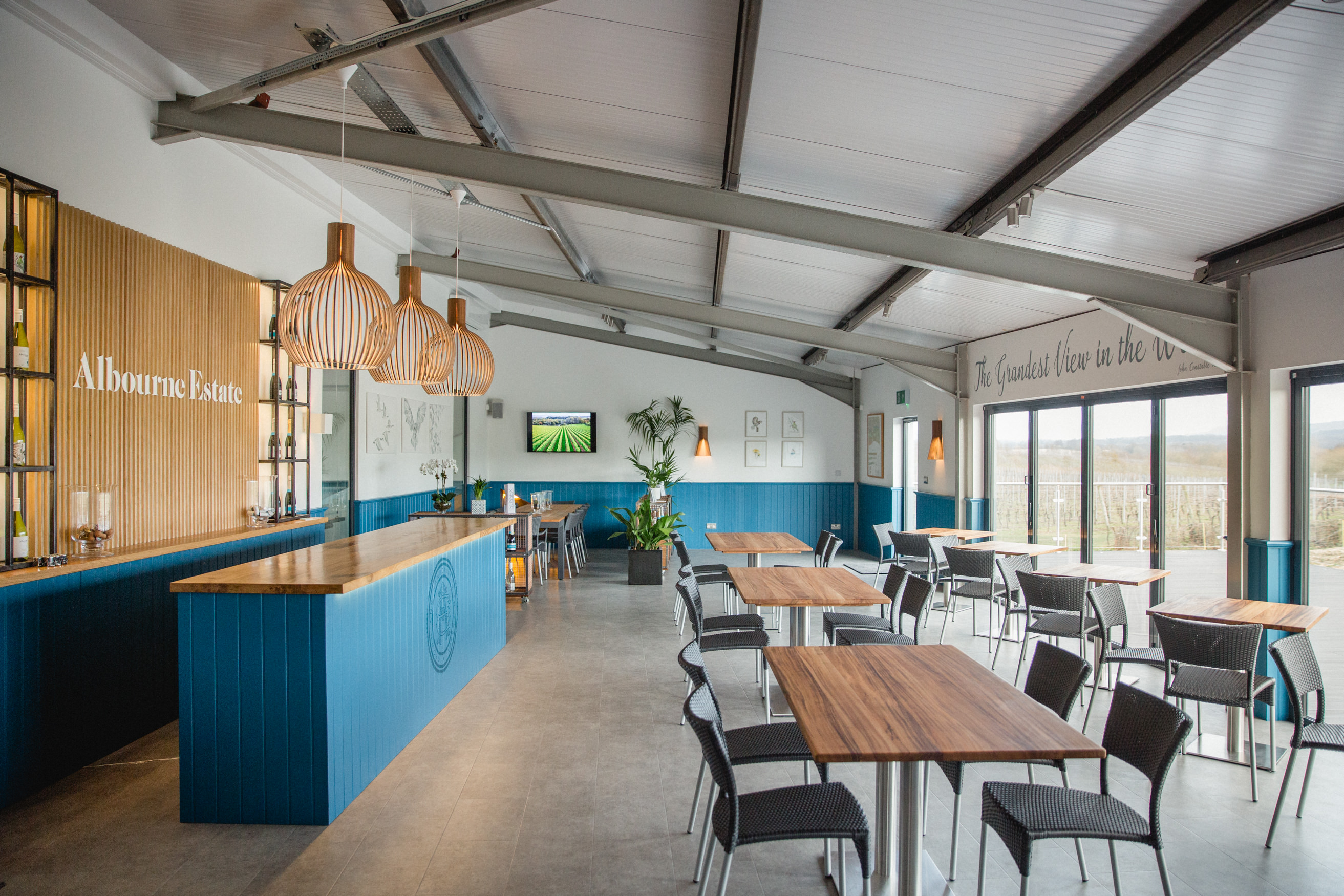 Modern event space at Albourne Estate with stylish bar and natural light. Perfect for gatherings.