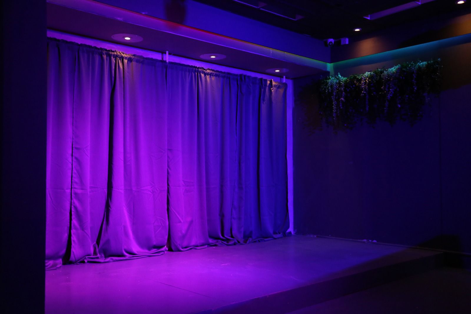 Stage setup with purple lighting in versatile event venue for presentations and performances.