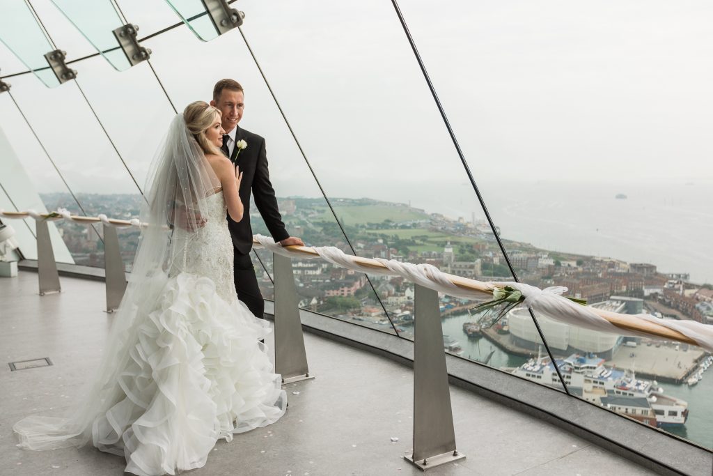 Wedding couple at Spinnaker Tower's View Deck 2 with panoramic backdrop, ideal for events.