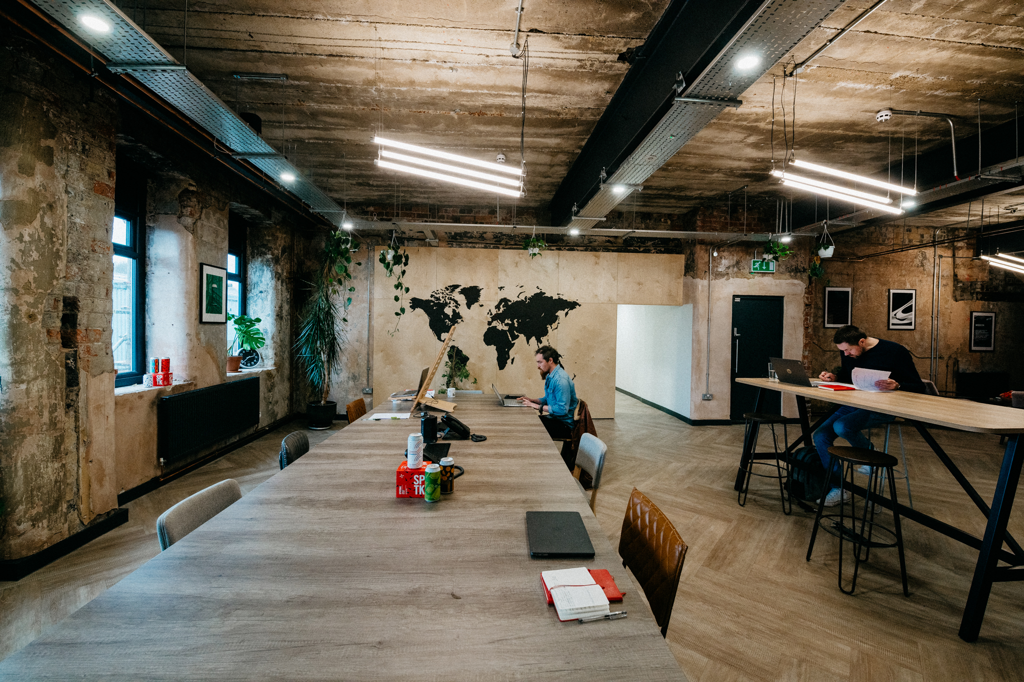 Modern meeting space at North Brewing Co with wooden table and world map mural.