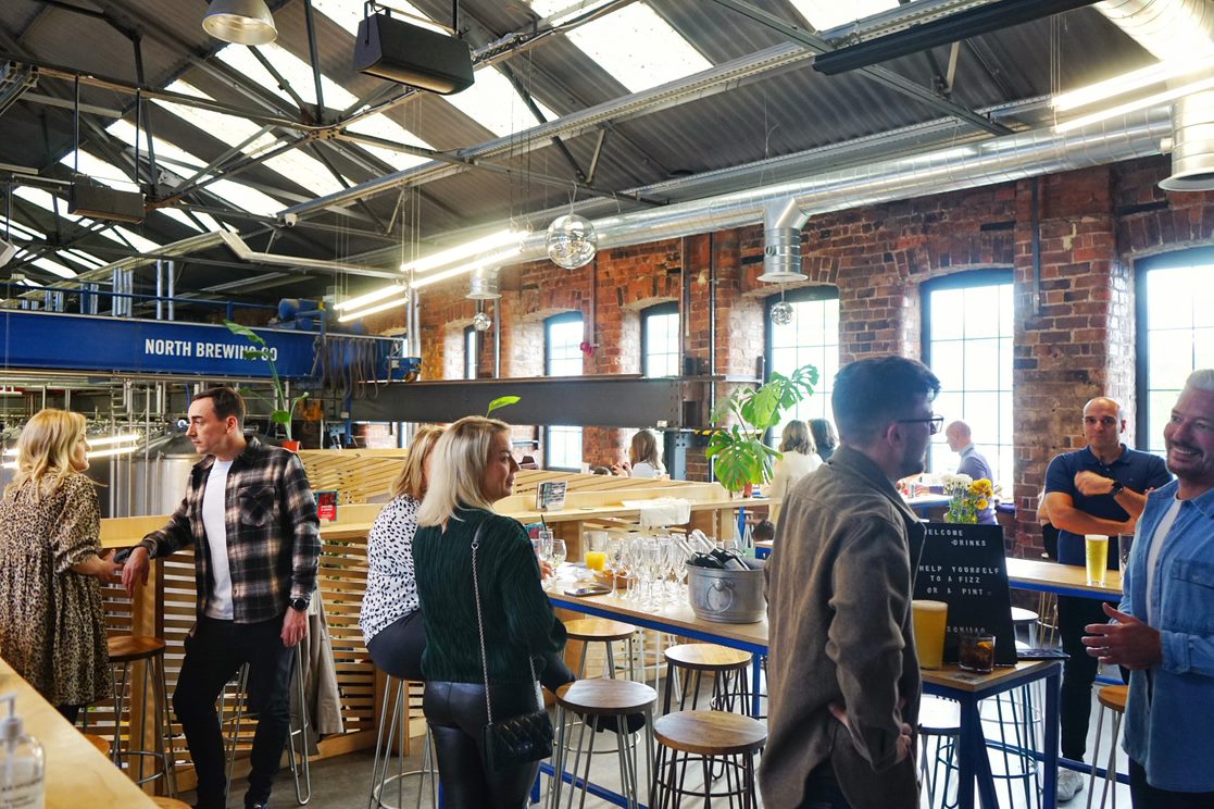 Vibrant networking event at North Brewing Co with industrial-chic decor and stylish bar.